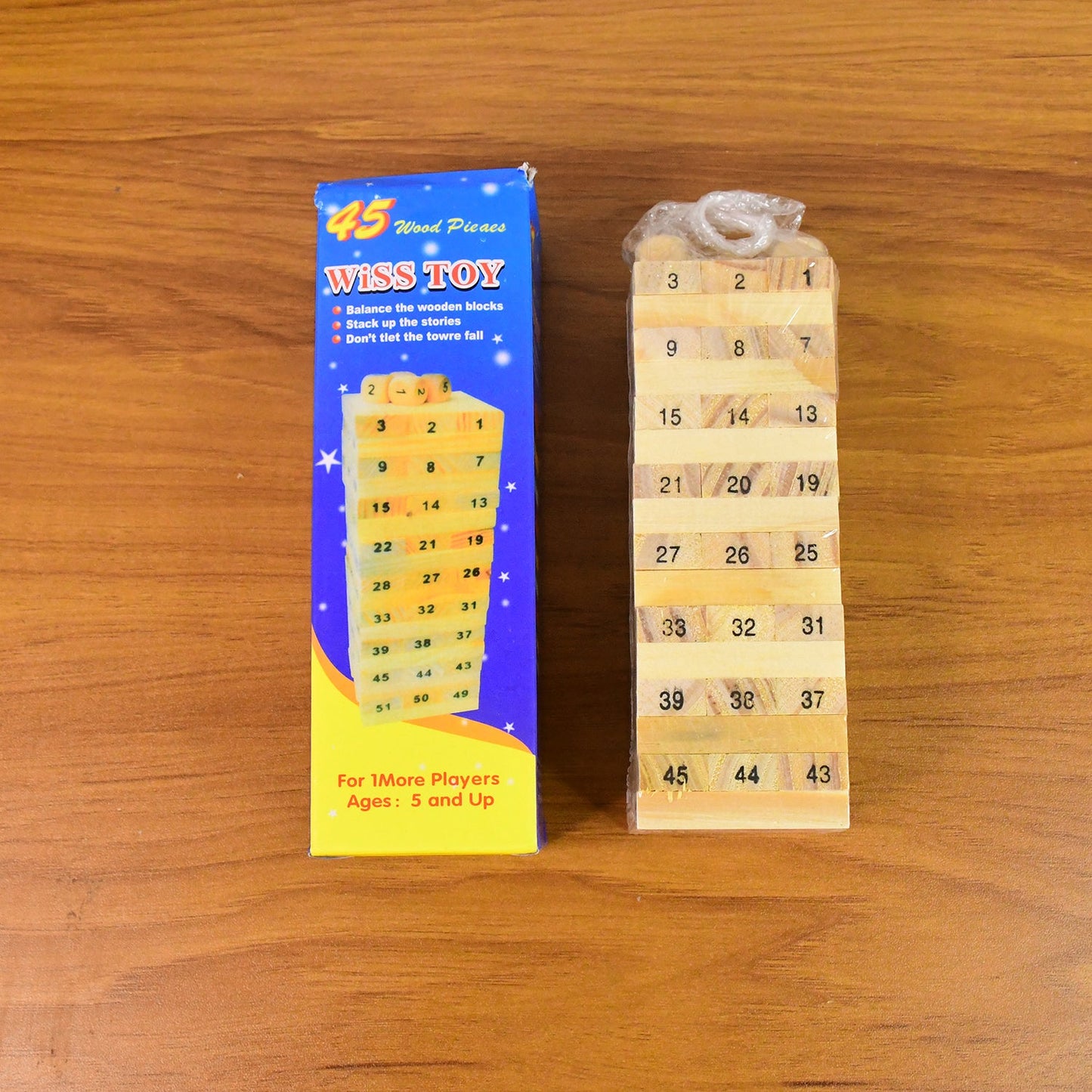 A stack of wooden blocks with dice beside it, illustrating the setup for the popular tumbling tower game.