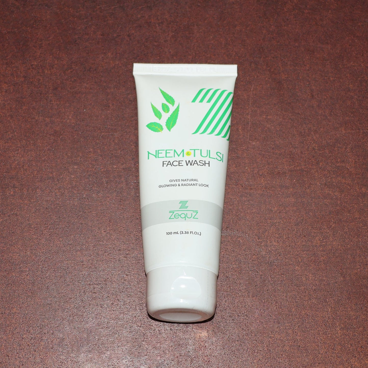 Zequz face wash tube with natural Neem and Tulsi leaves background