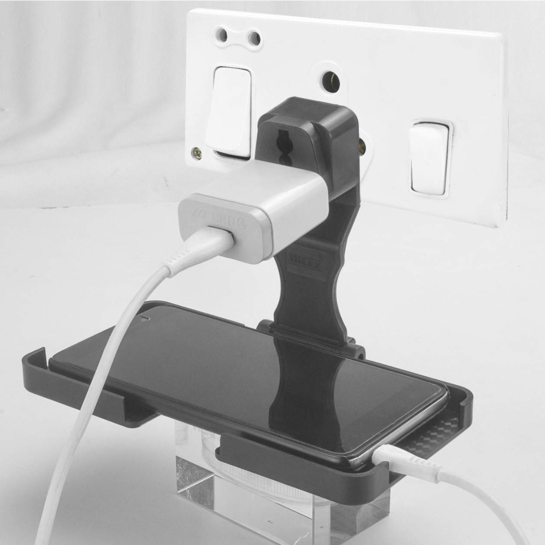 PHOBIA black multi-purpose wall mount stand holding a phone on a wall socket.