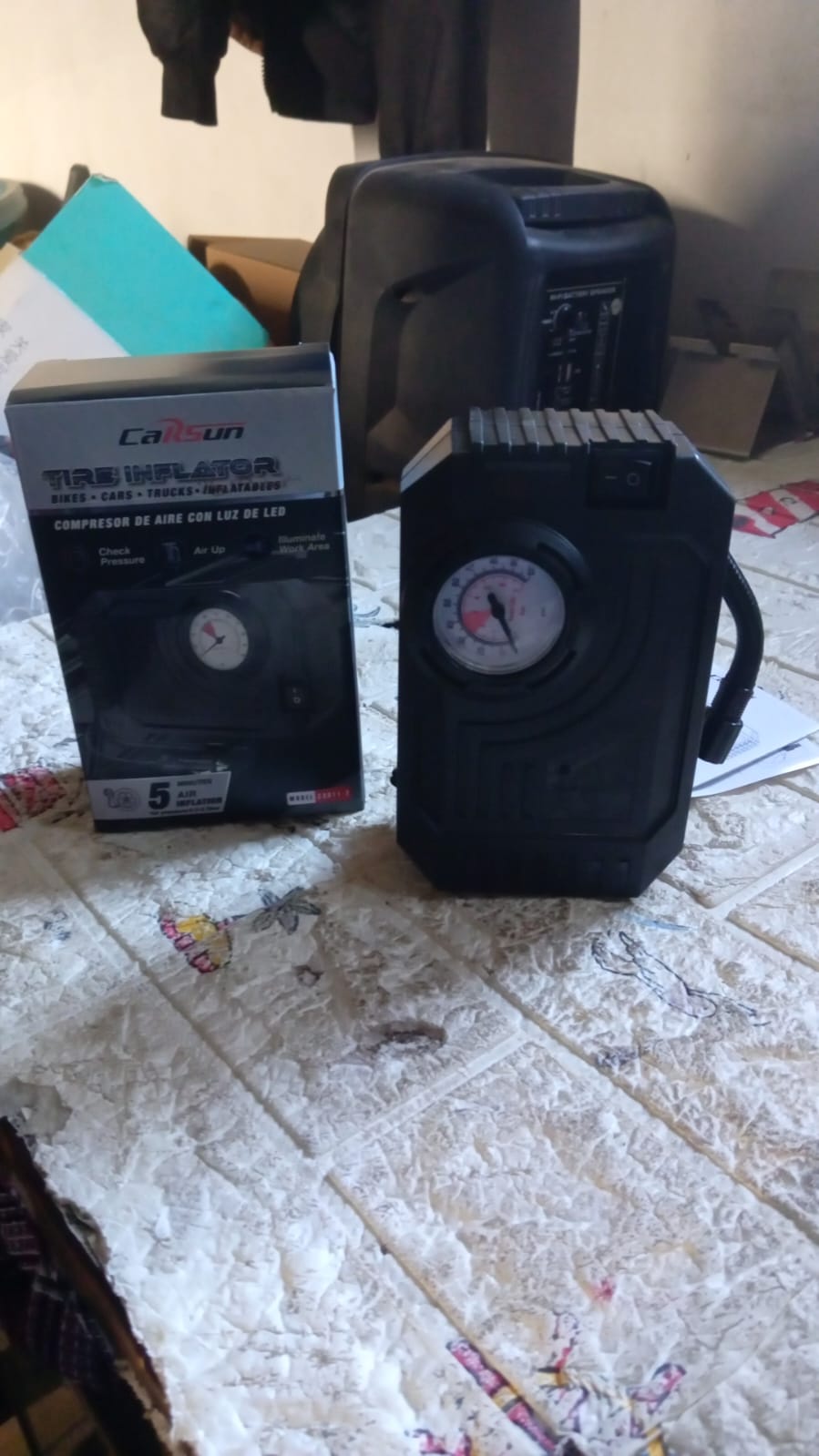 Portable 12V tire inflator kit with all accessories displayed on a clean surface.
