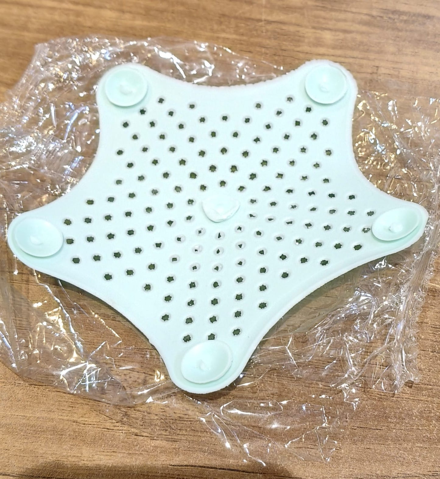 Star shaped silicone sink strainer protecting kitchen sink from hair and debris