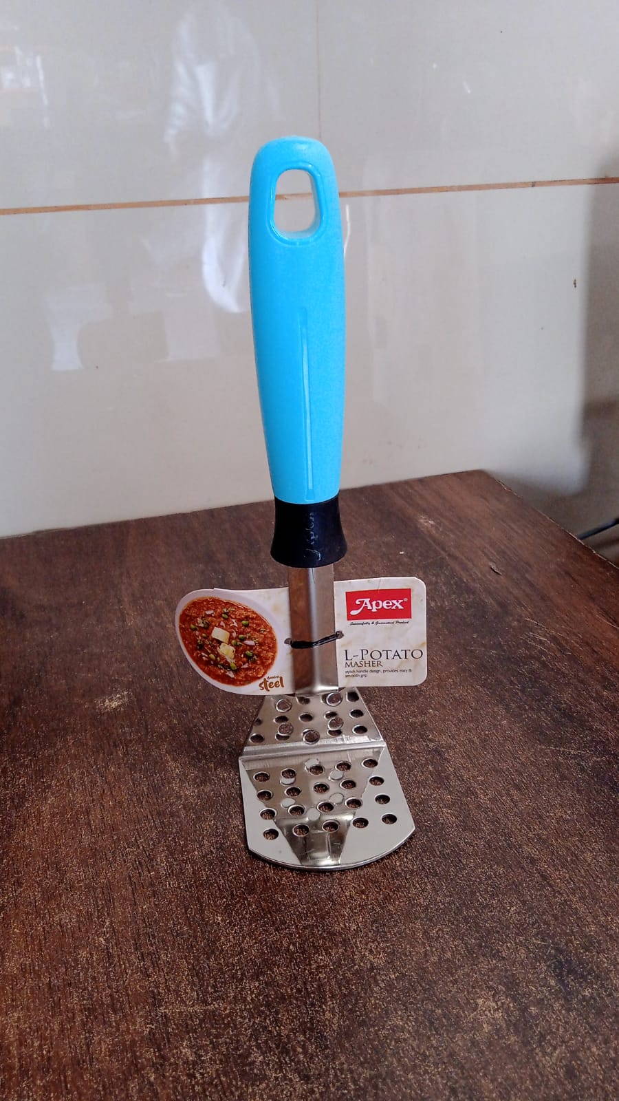 Stainless steel potato masher placed on kitchen counter