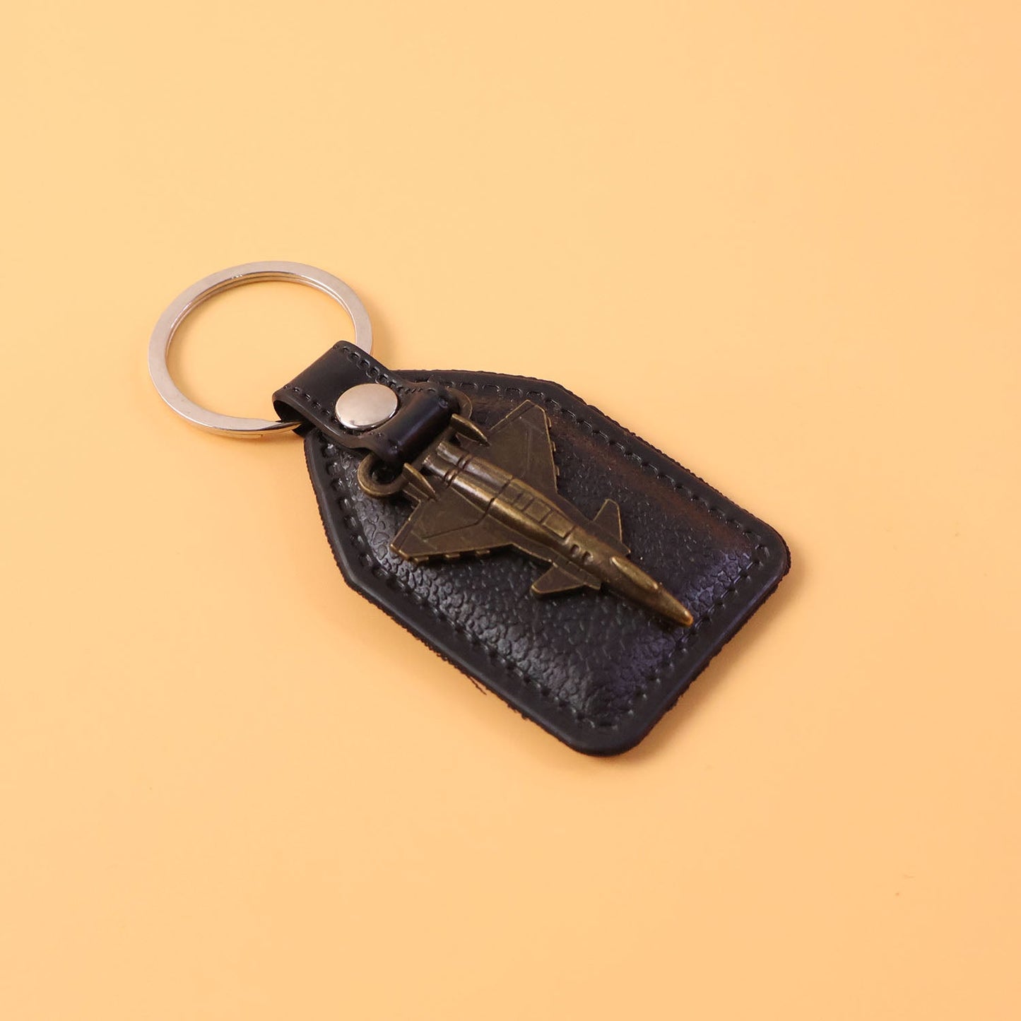 Close-up of decorative vintage style aircraft emblem on leather finish keychain