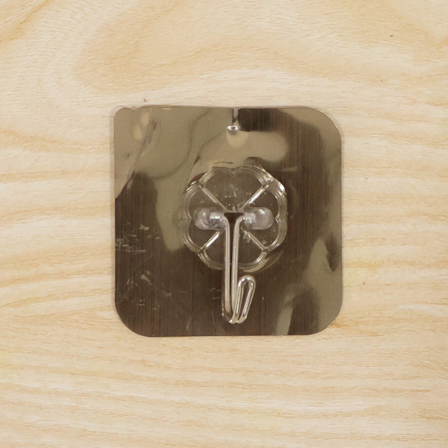 Self-adhesive metal floral wall hook mounted on smooth surface for household use
