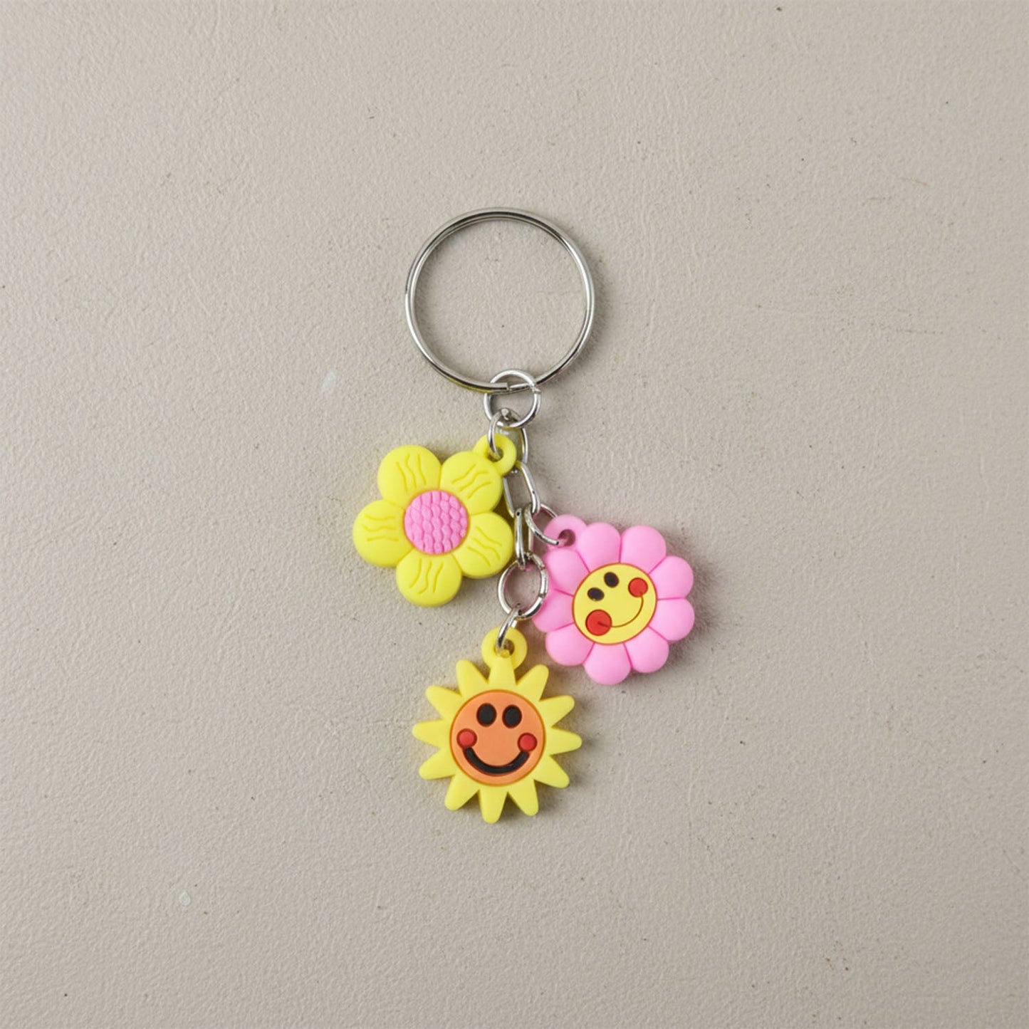 Flower smiley face cartoon keychain showcasing metal ring attachment