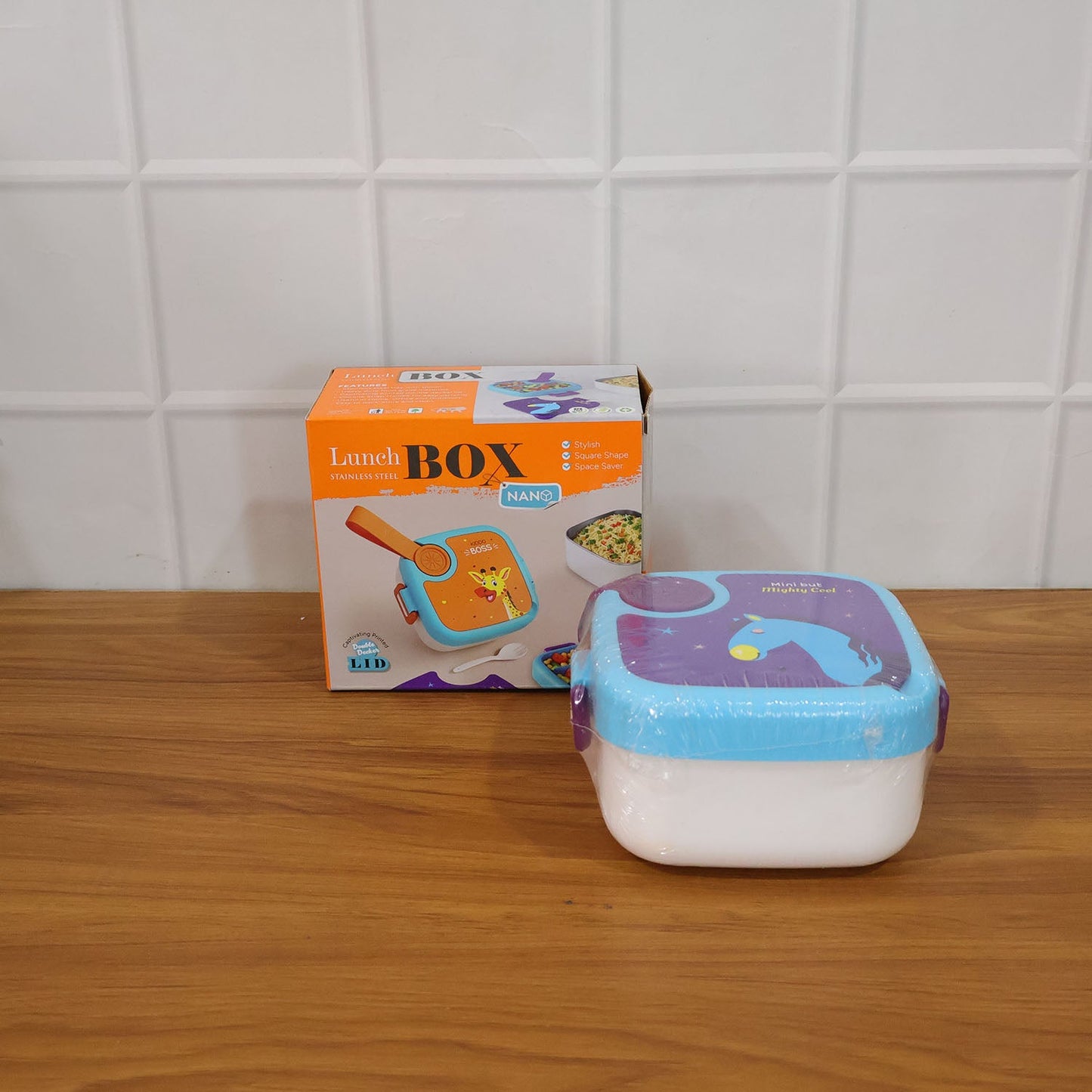 Kids lunch box on a table displaying the giraffe print and stainless tray