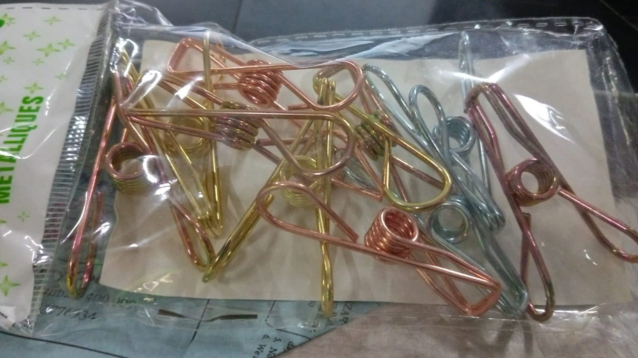 Lifestyle shot of sturdy stainless steel clips being used to hang clothes on a line.