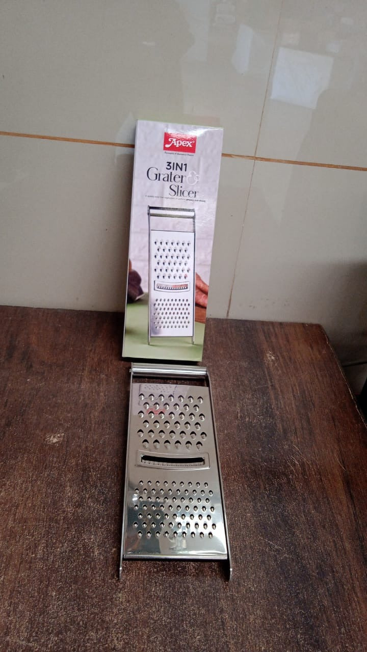 Stainless steel grater and slicer placed in a kitchen setting for food prep