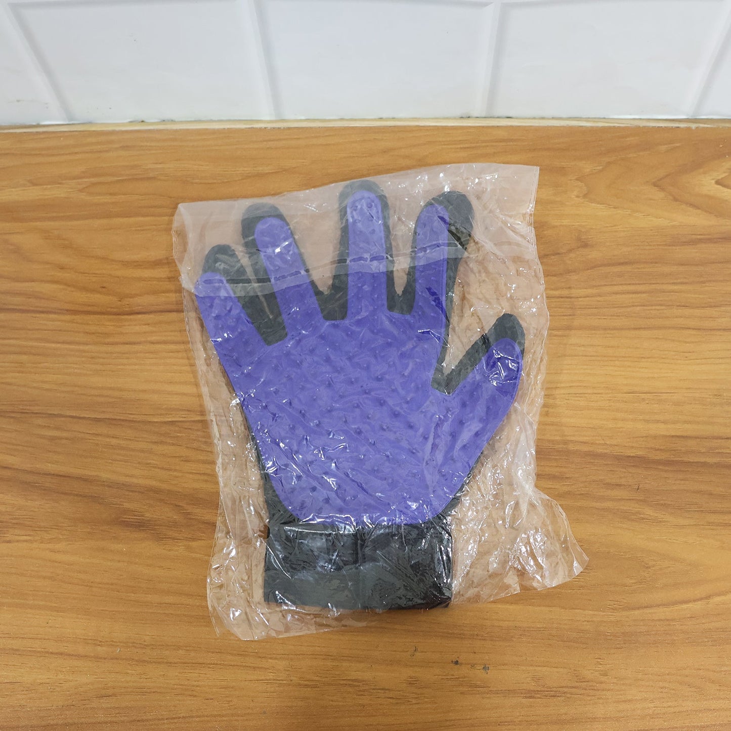 A real-time action shot of the pet deshedding glove removing loose fur from a pet.