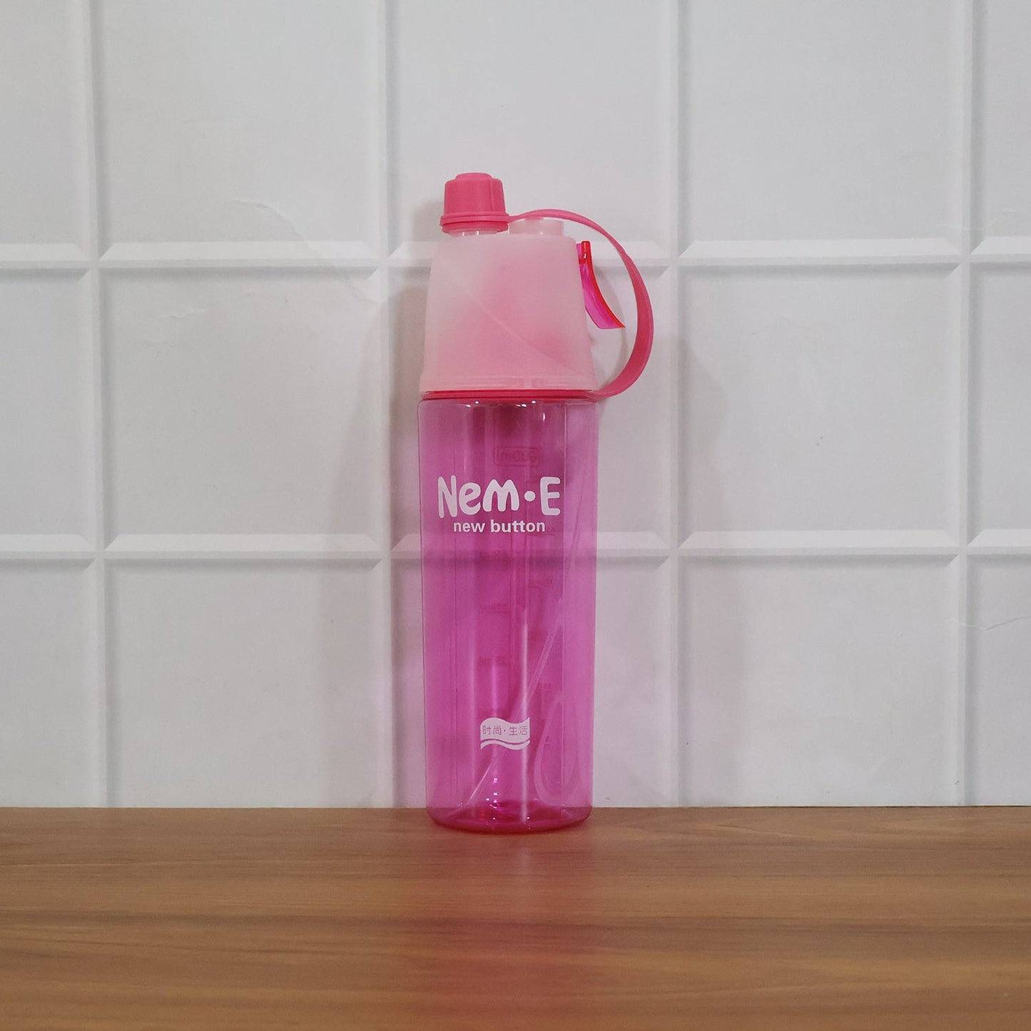 In use: pink sports water bottle with mist spray feature active