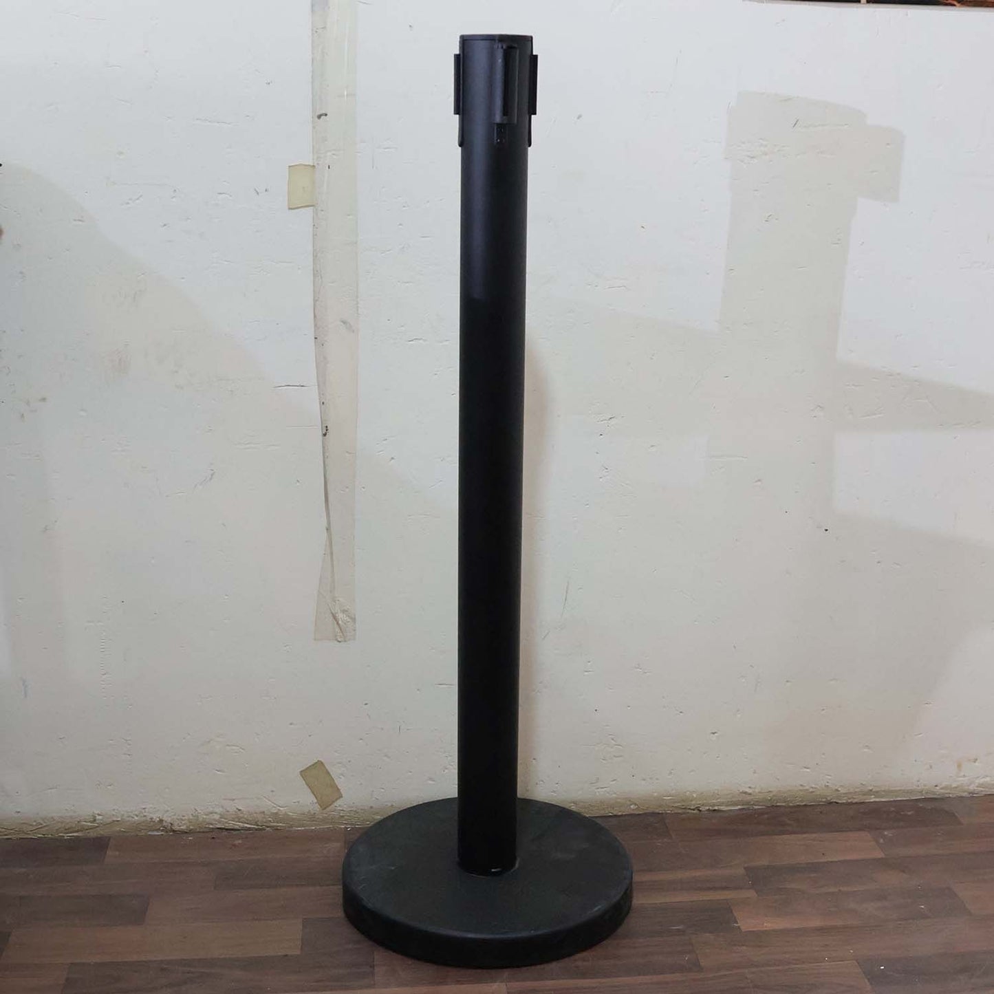 Crowd control pole with retractable belt in use at event venue