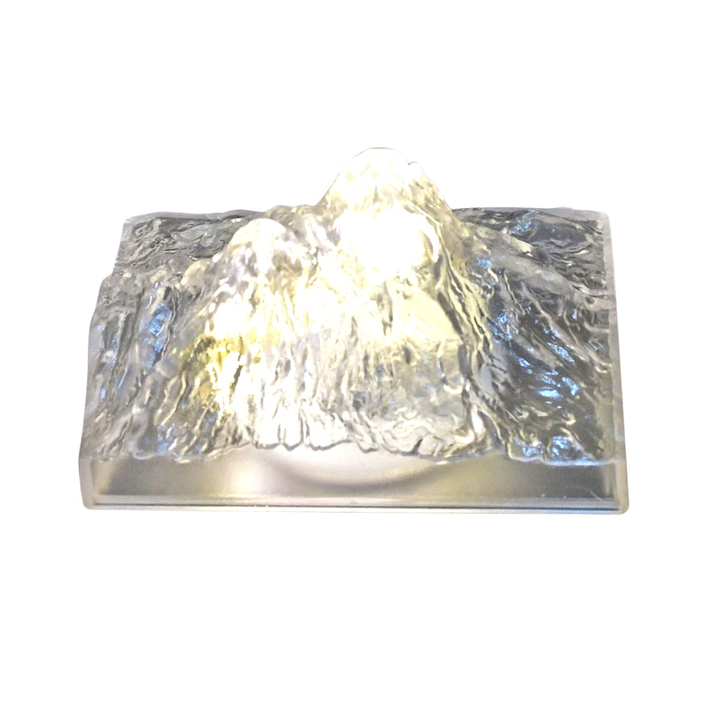 The Iceberg Night Light placed on a wooden surface, emitting a warm, ambient glow.