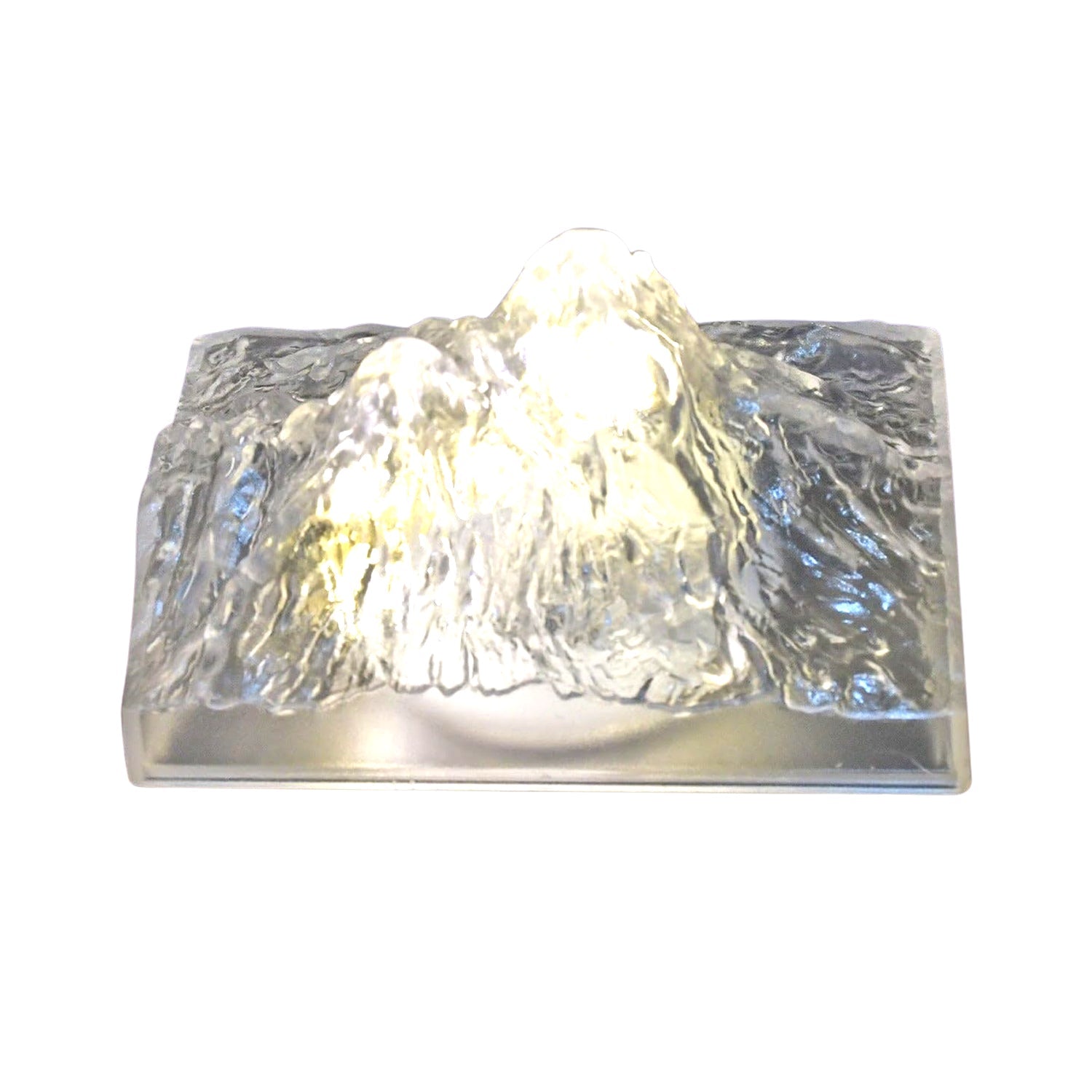 The Iceberg Night Light placed on a wooden surface, emitting a warm, ambient glow.