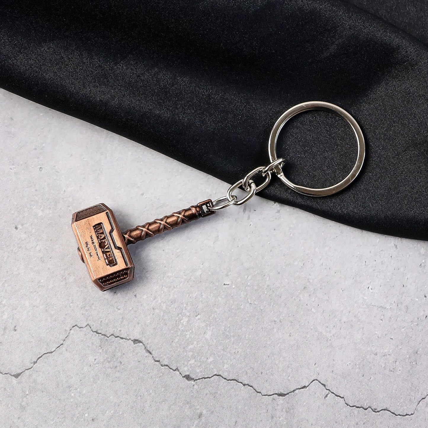 Metal Hammer Keychain with antique bronze finish on neutral background