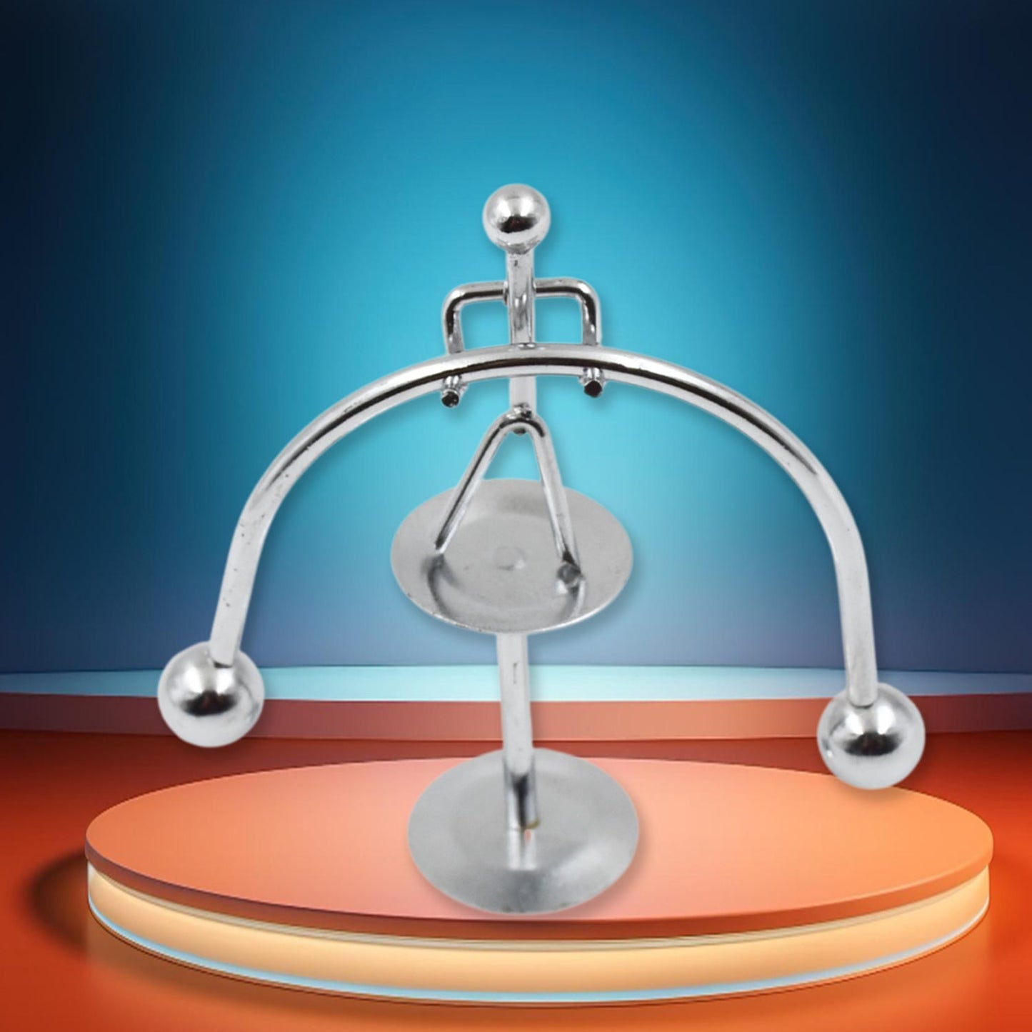 The Mini Steel Balance Toy in motion, demonstrating its perpetual swing on a desk.