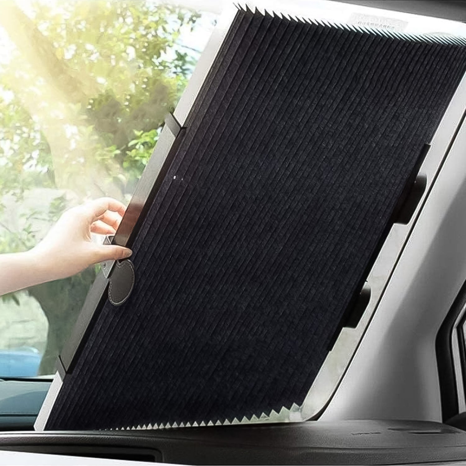 Driver installing the retractable car windshield sun shade with suction cups.
