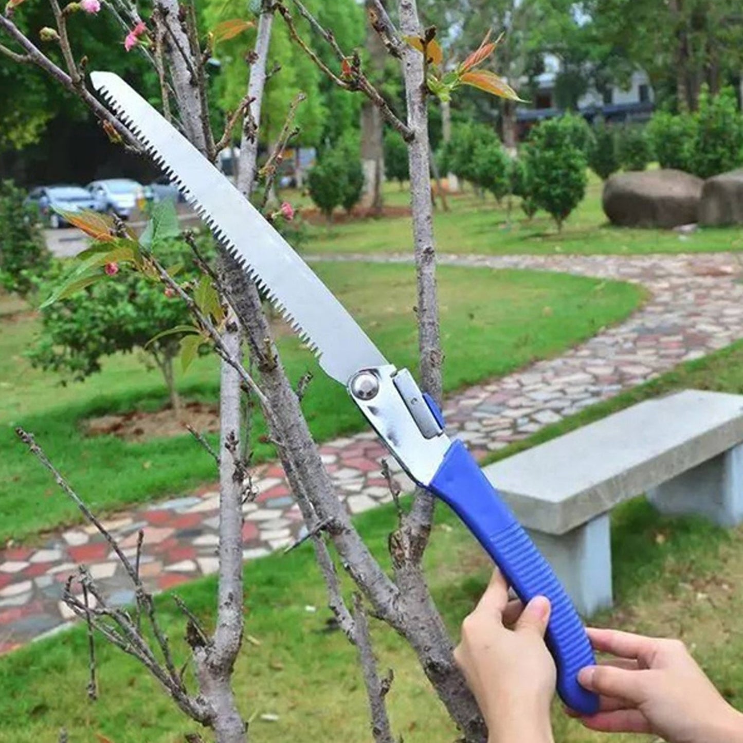 Folding gardening saw efficiently cutting a thick branch.