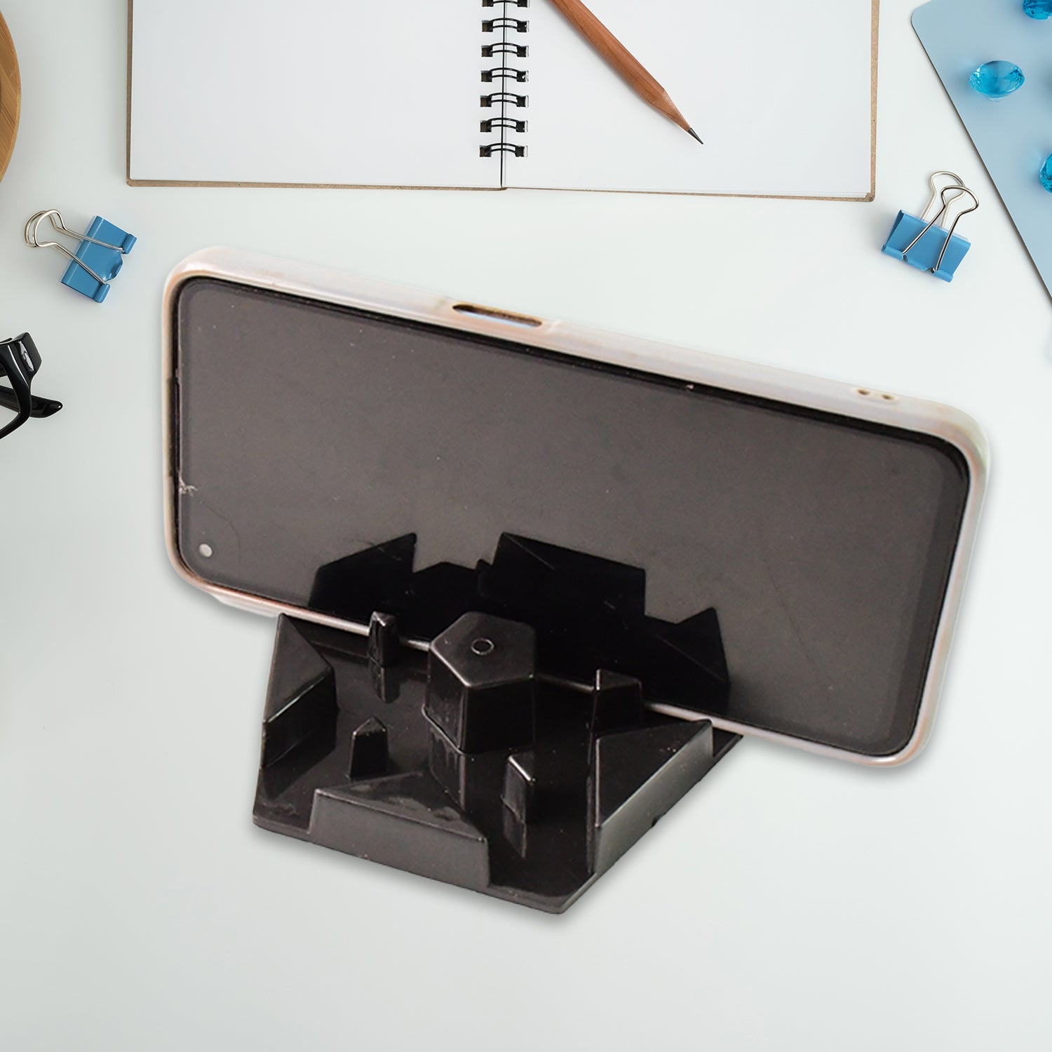 Multi-angle hexagonal plastic mobile phone stand positioned on desk