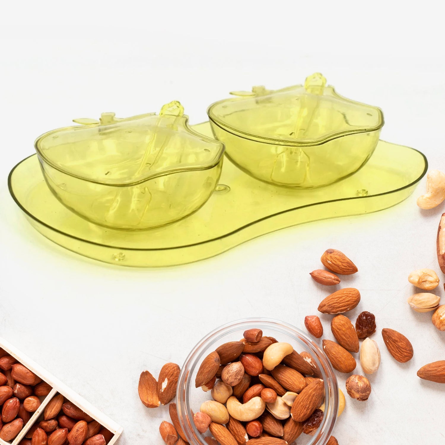 Apple-shaped plastic serving tray filled with assorted snacks.