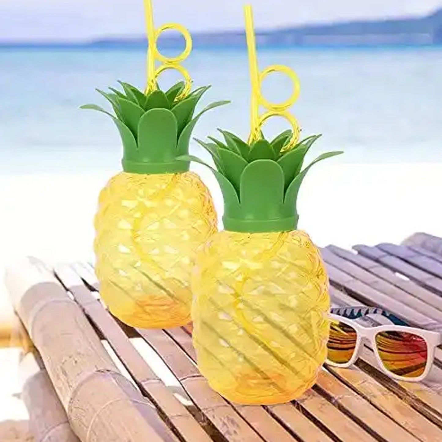 Top-down view of the pineapple cup with its green leaf lid and reusable straw.