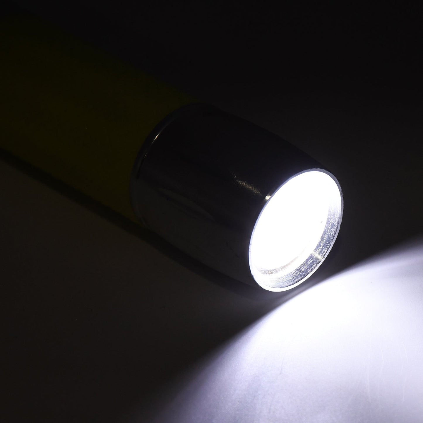 A person using the portable torch to illuminate a dark space, demonstrating its effectiveness.