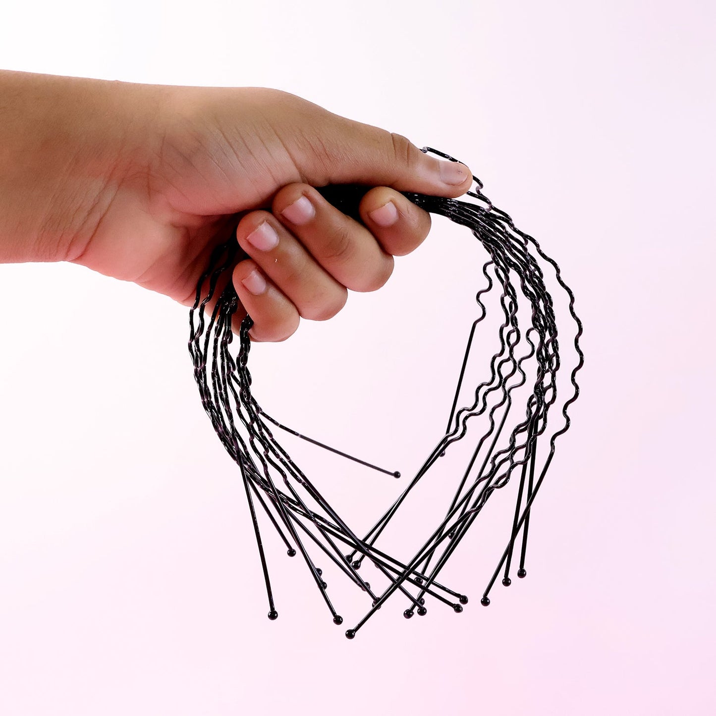 Black metal wavy headband displayed on white background