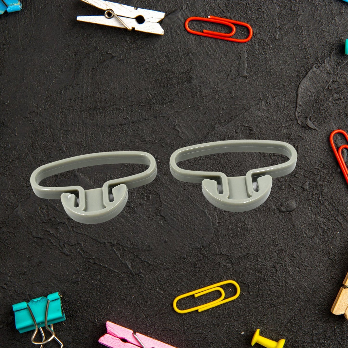 Two multifunctional plastic bag handle holders displayed, highlighting their compact design.