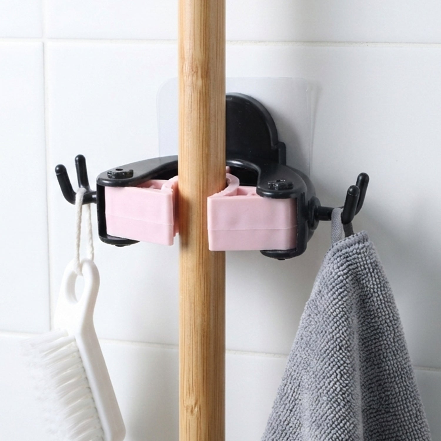 Wall mounted clip holder for mop and broom in use