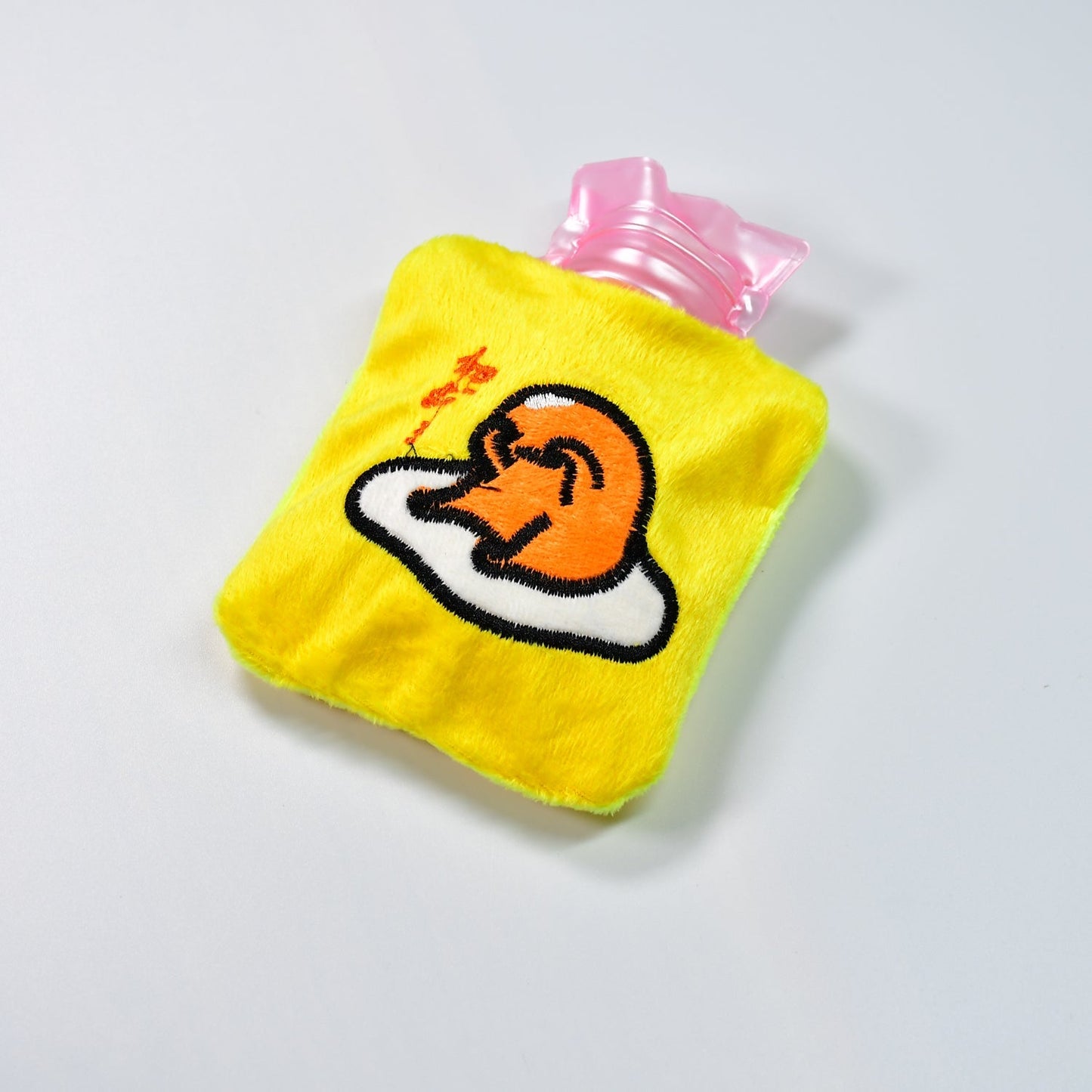 Bright yellow duck head hot water bag with a soft fabric cover for comfort.