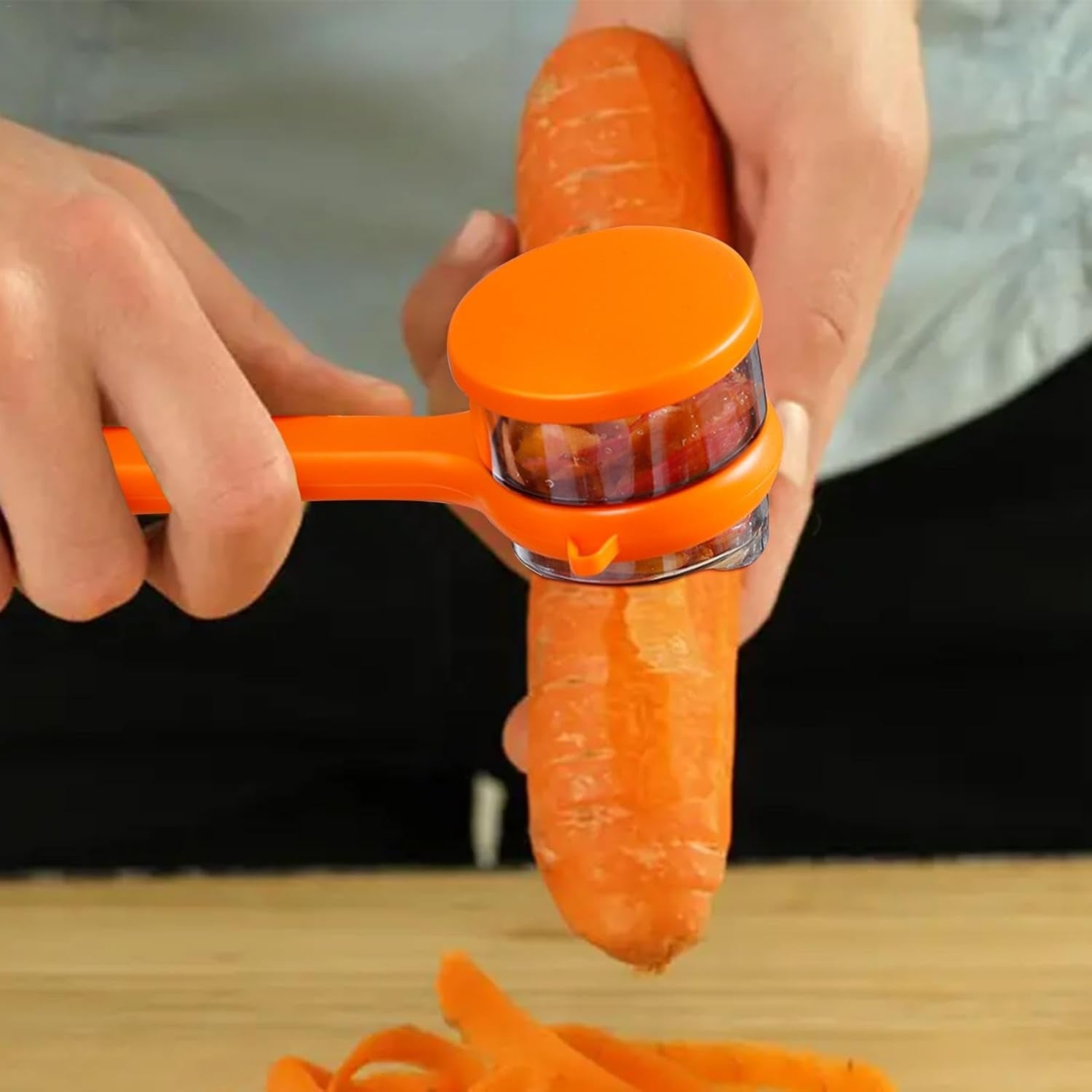 Peeler blade peeling a carrot with container collecting peels