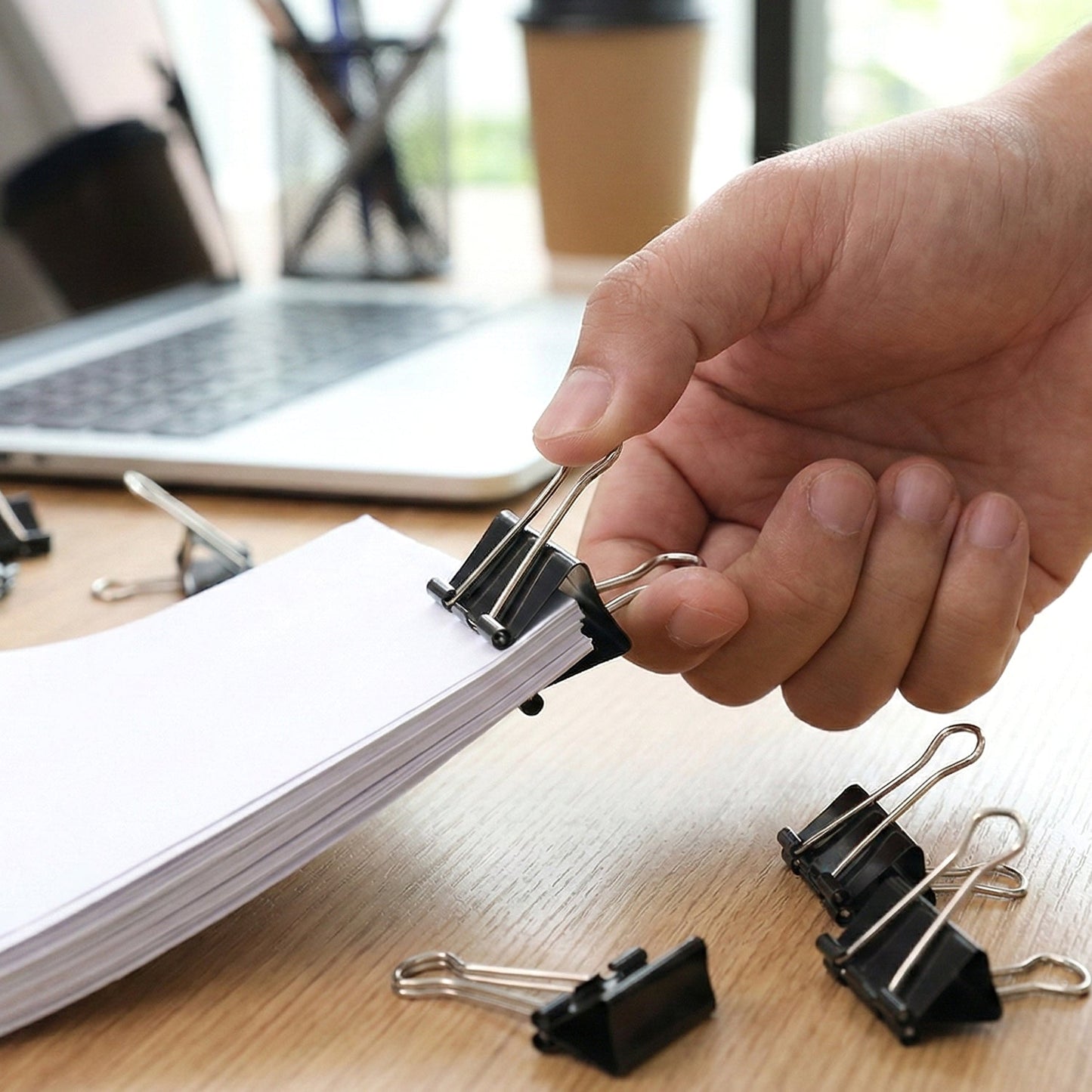 Paper secured with 51 mm large binder clips for document organisation