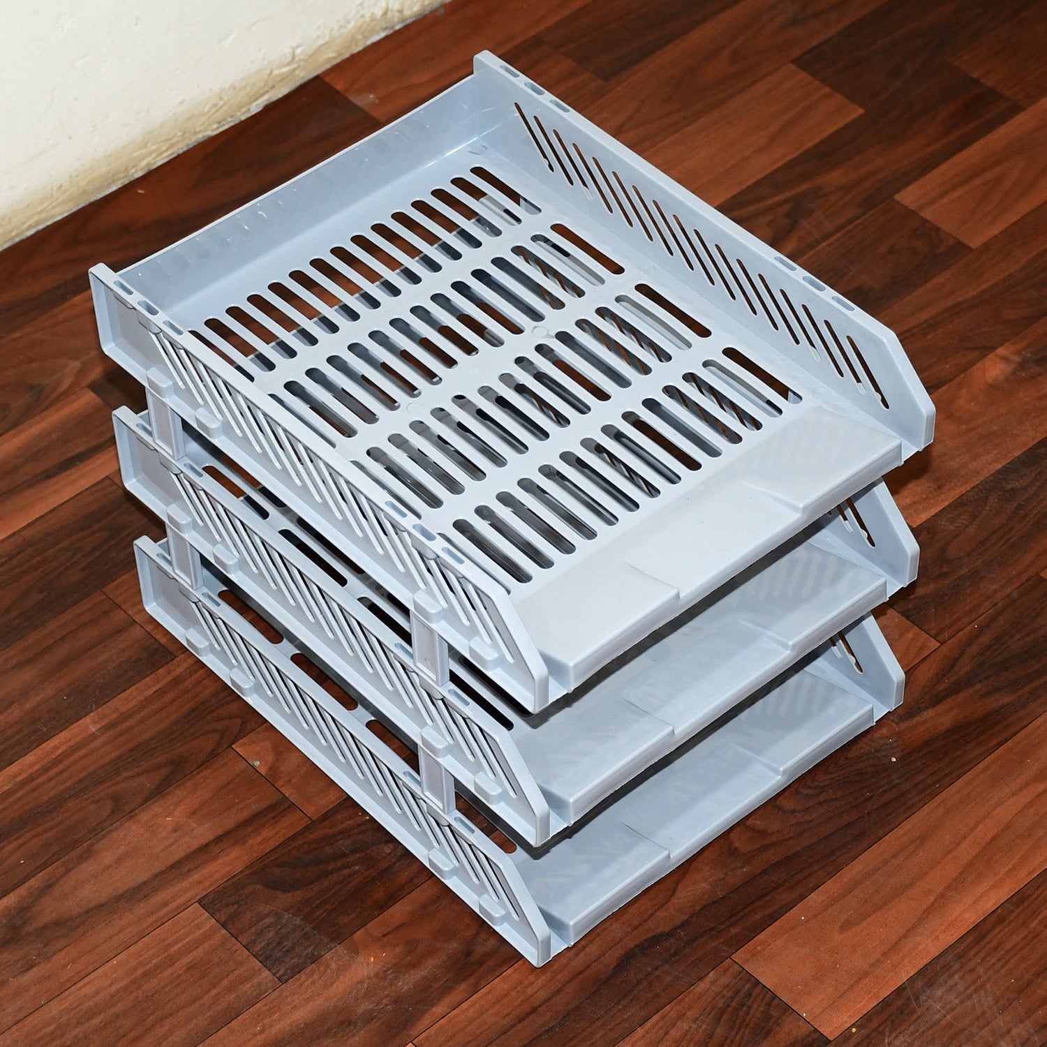 Three-layer desktop file rack drawer on a modern office desk.