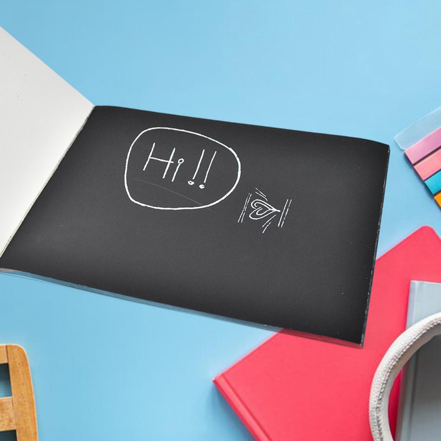 Child using wooden stylus to scratch and reveal colourful art sheet