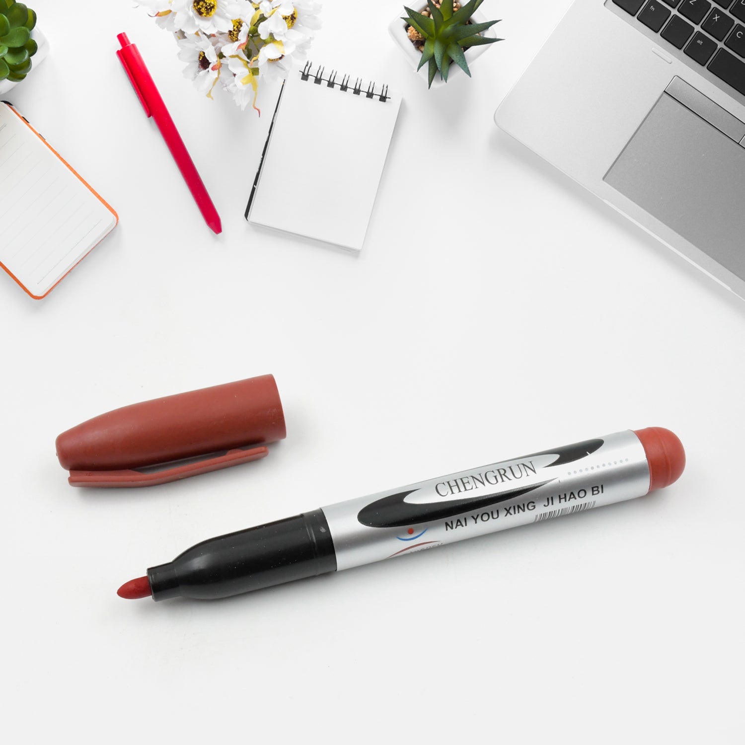 Group of maroon permanent markers arranged neatly on a surface.
