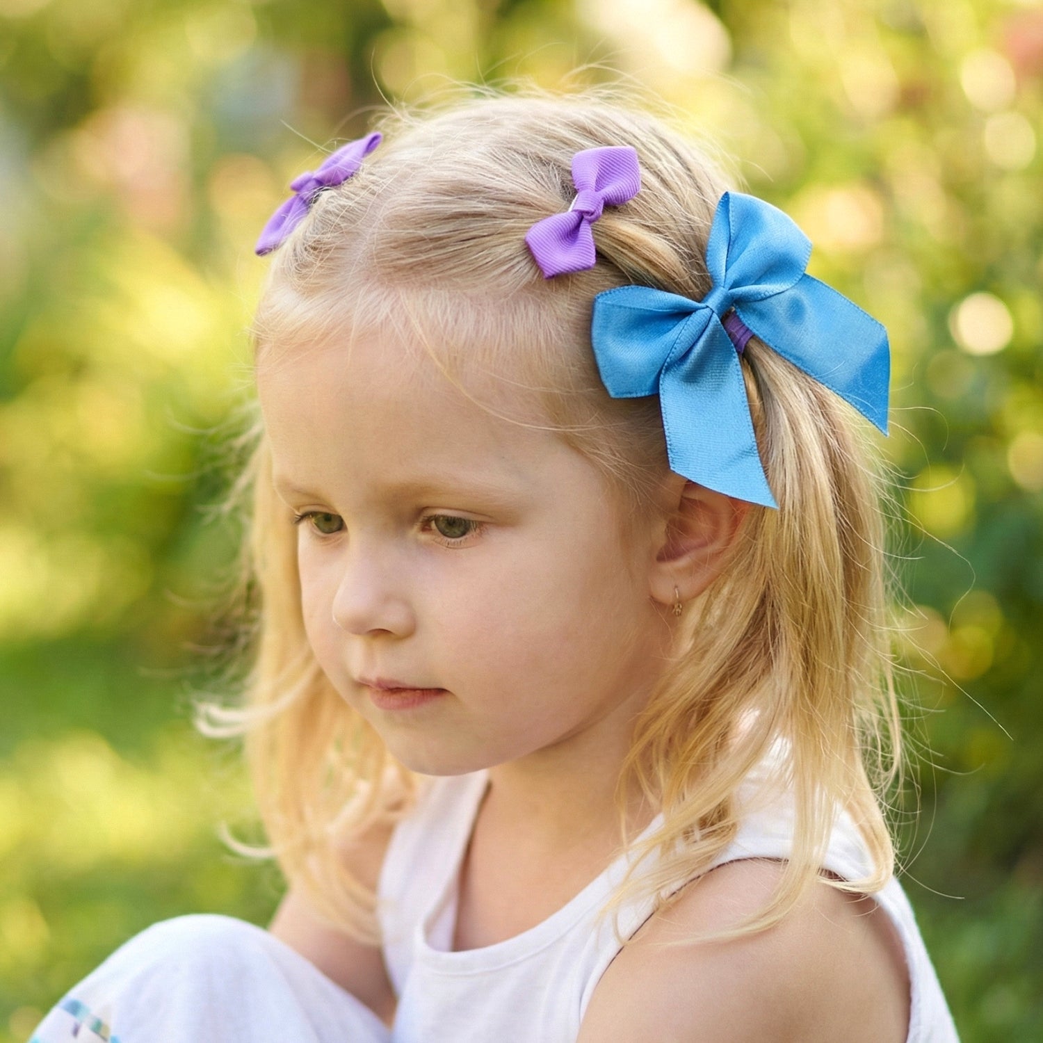 Three ribbon bow hair clips with smooth satin fabric texture