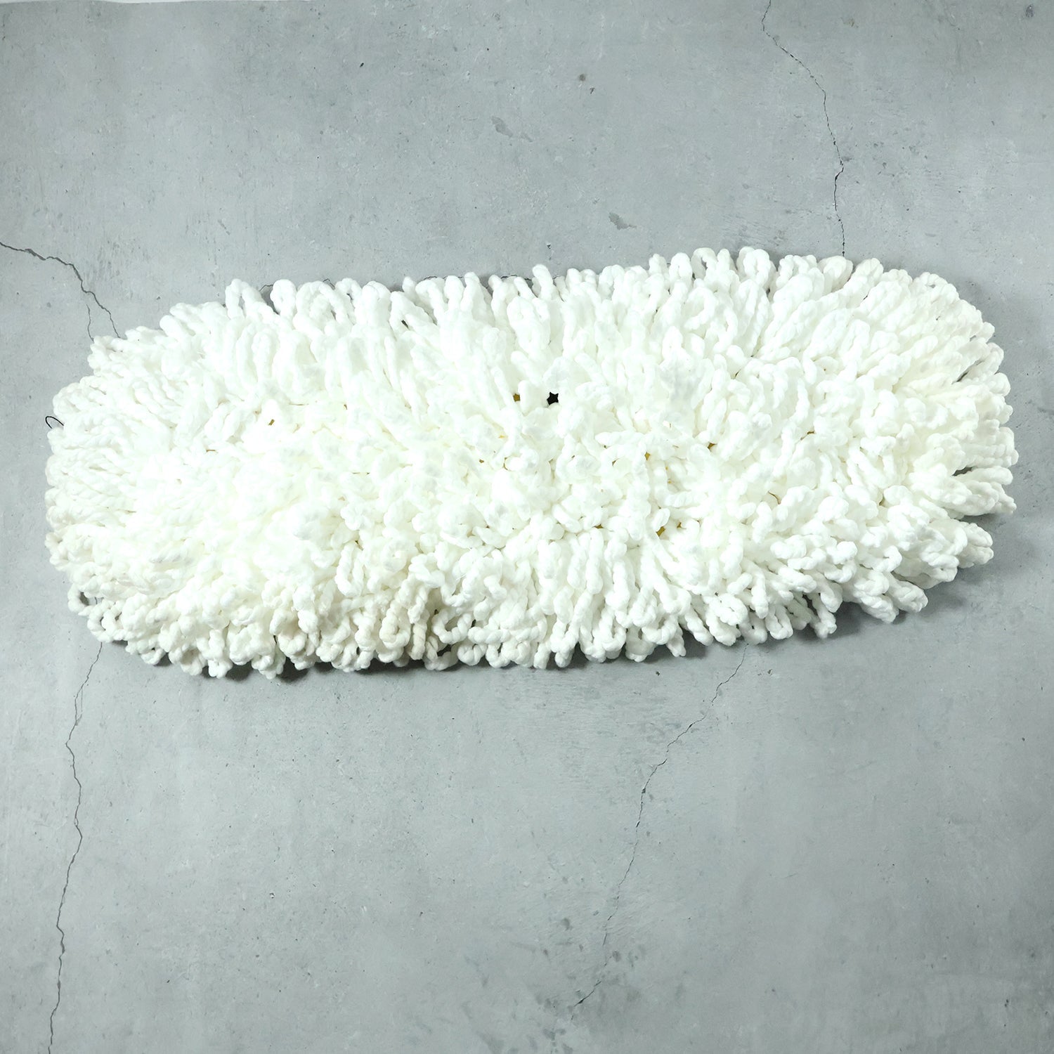 Freshly washed dust mop refill head drying naturally.