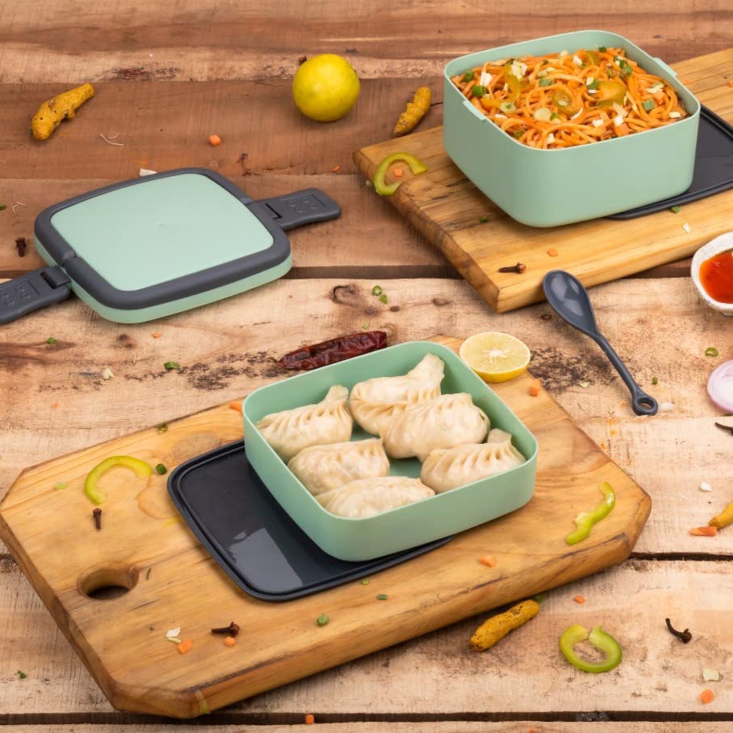 Green stackable lunch box with two layers and a carrying handle.