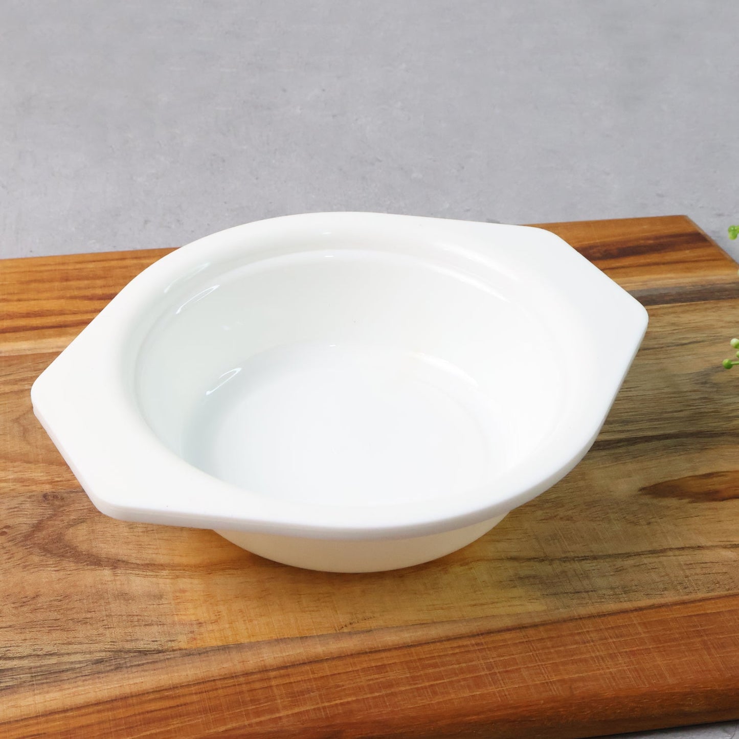 Plastic serving and mixing bowl with easy-grip side tabs on white background