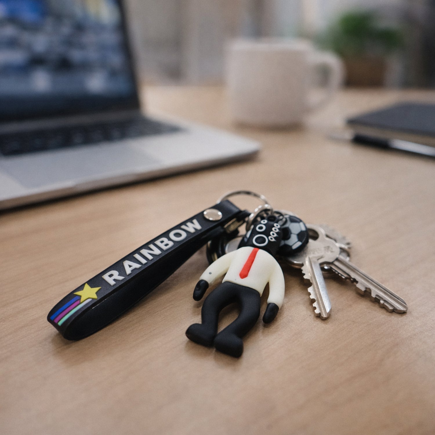 Playful football boy keychain with rainbow strap, attaches easily to keys and bags