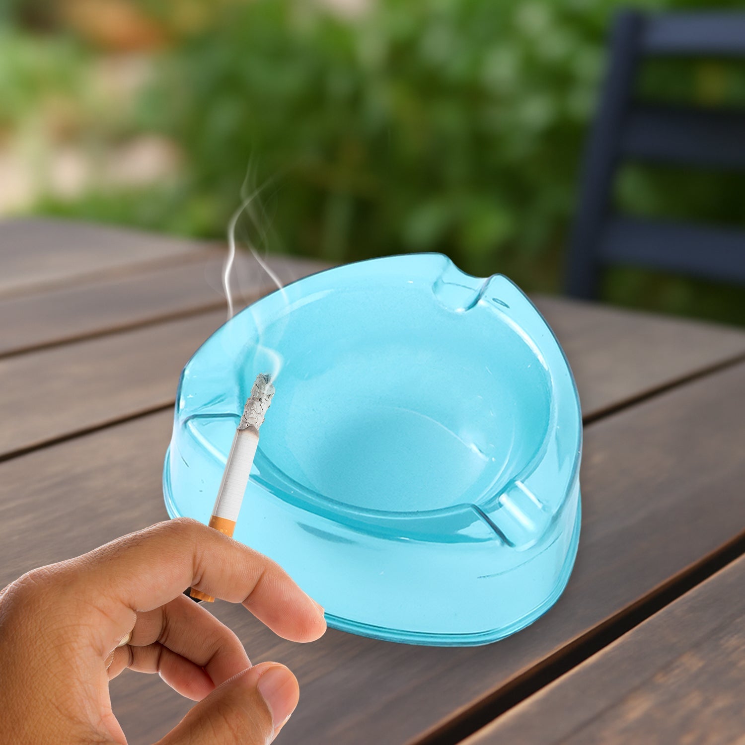 Clear transparent plastic ashtray showing triple cigarette rests