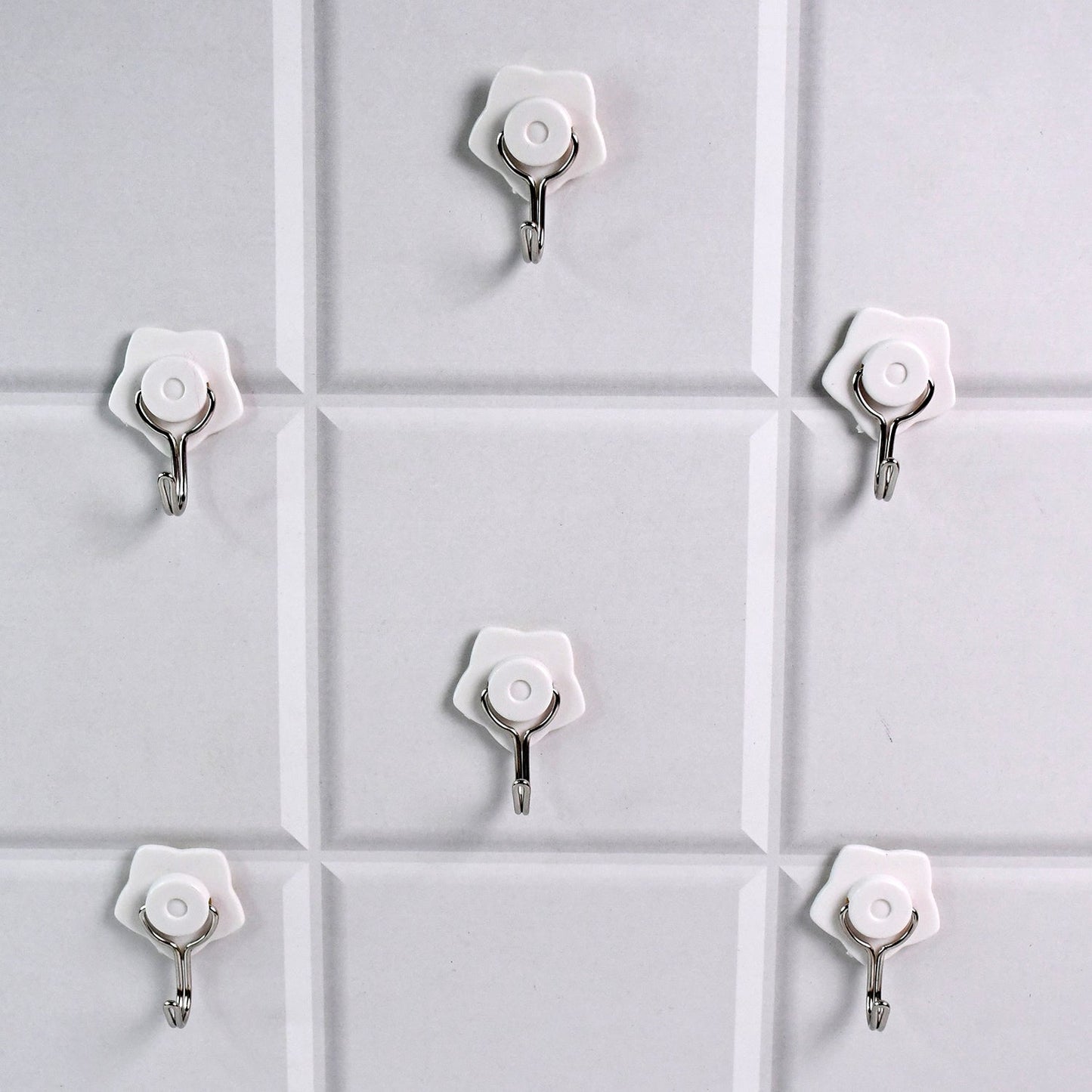 A yellow self-adhesive hook securely holding a towel in a modern bathroom.