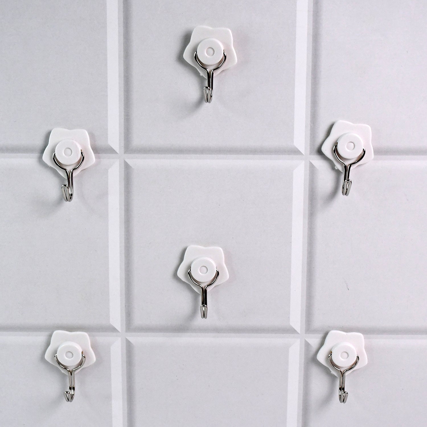 A yellow self-adhesive hook securely holding a towel in a modern bathroom.