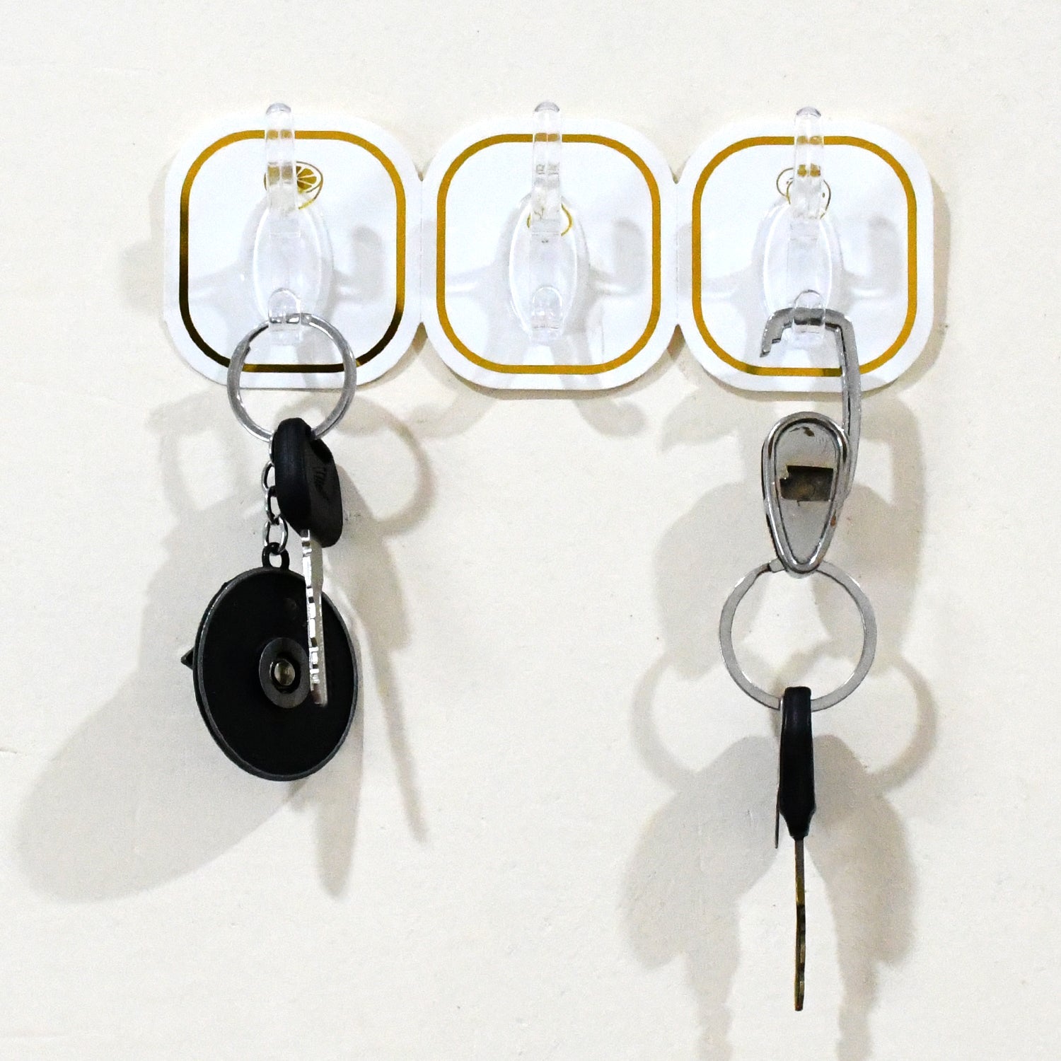 Close-up of a clear plastic transparent adhesive hook with a stainless steel hook.