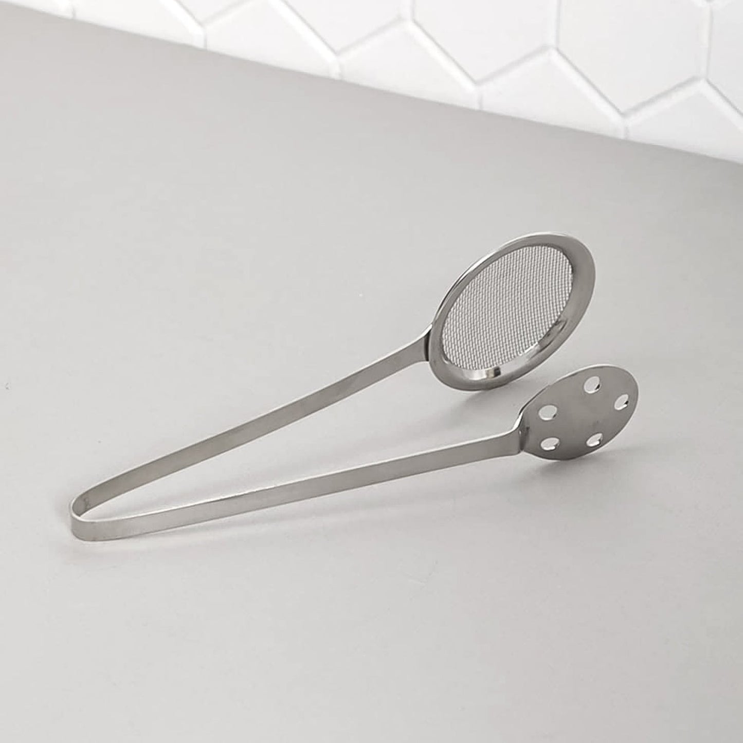 Polished steel serving tong with dual mesh and perforated sides for draining food