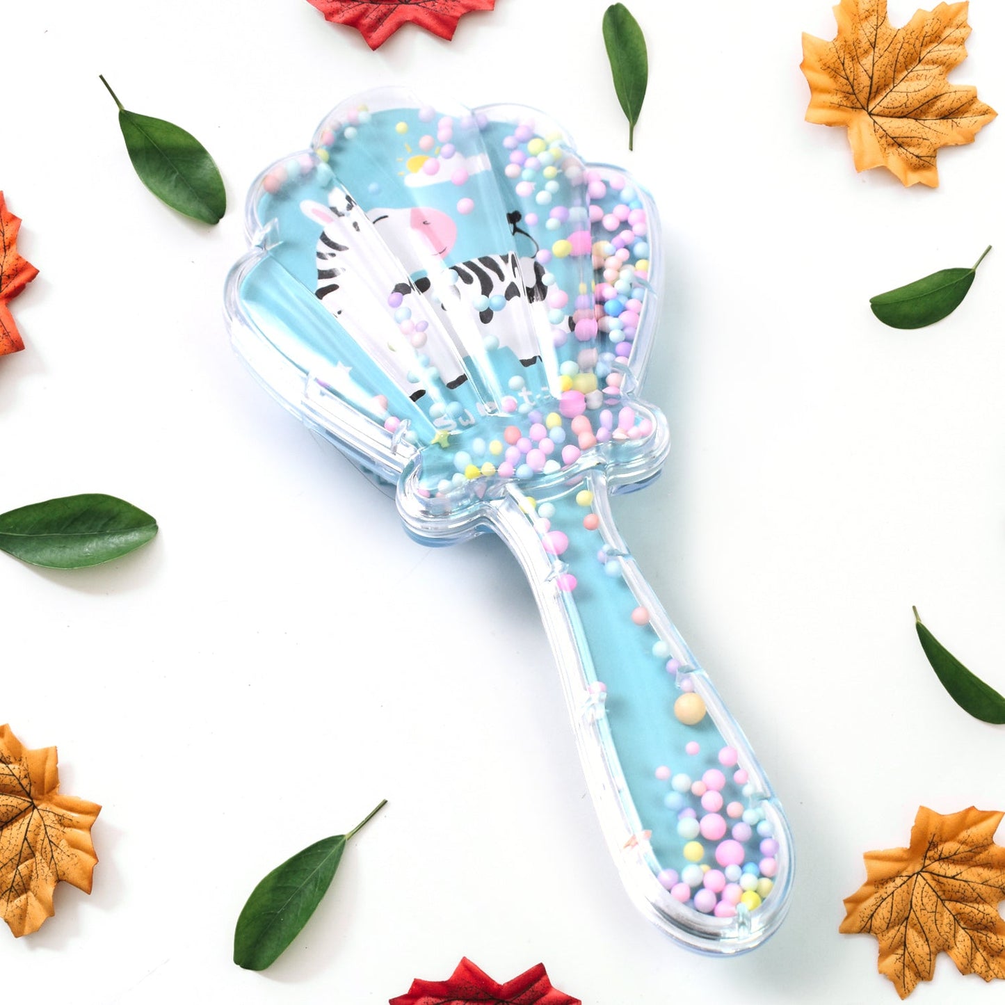 Back view of the kids' detangling hair brush, showcasing the unique cartoon design and paddle shape.