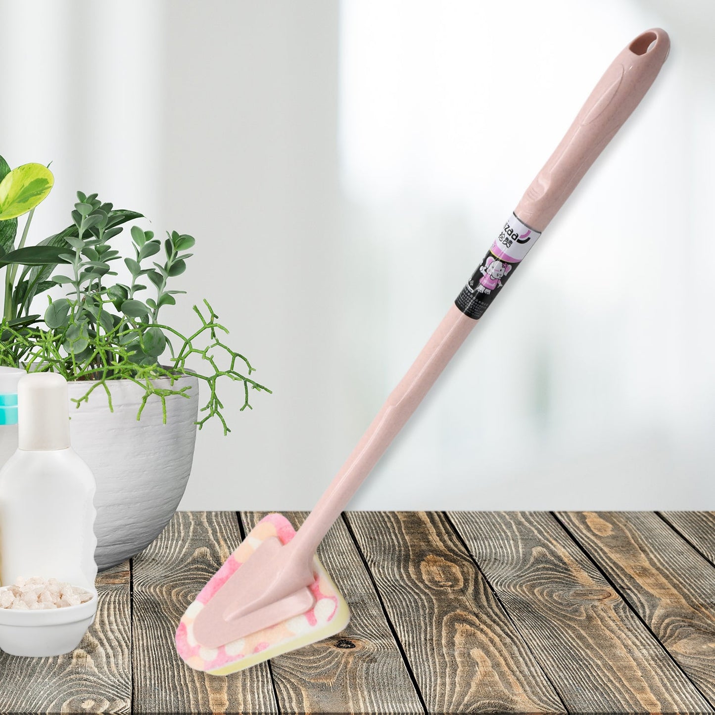 Triangular cleaning brush with long handle, ready for kitchen use.