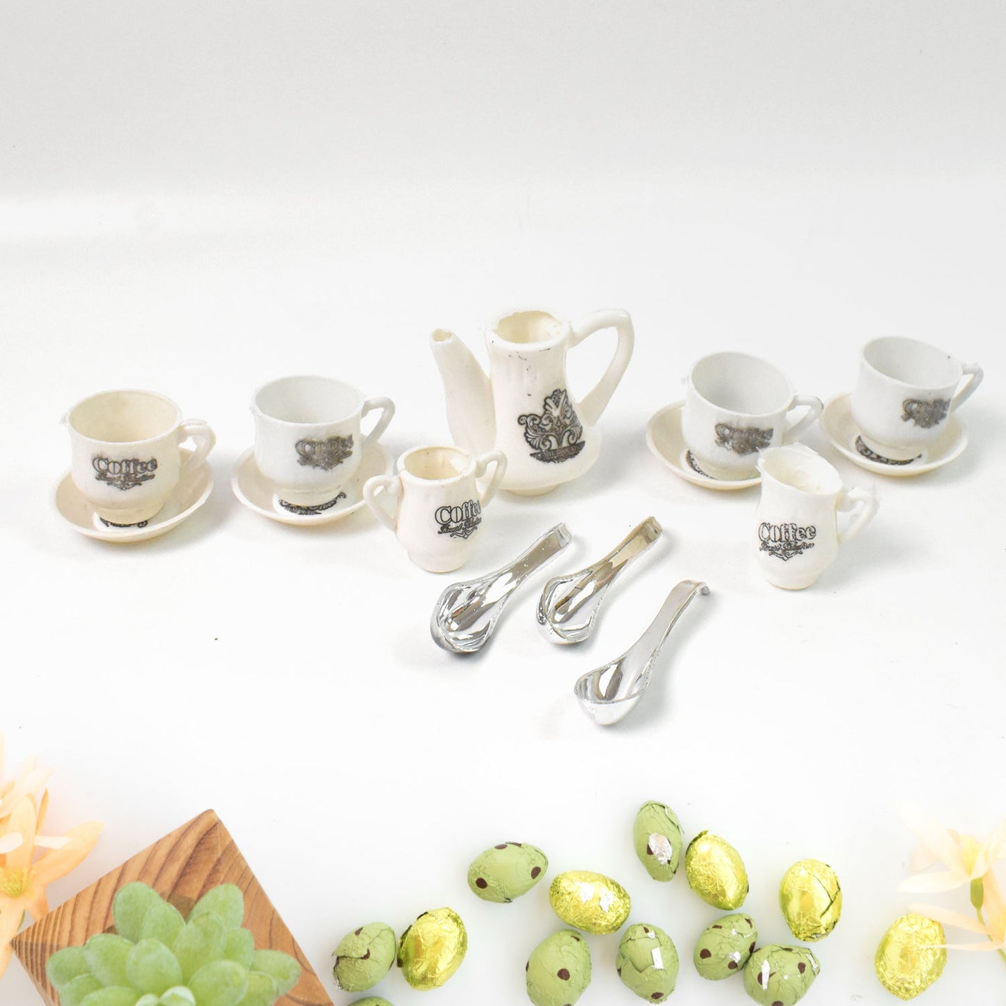 Miniature plastic cups, saucers, and spoons arranged for a pretend tea party.