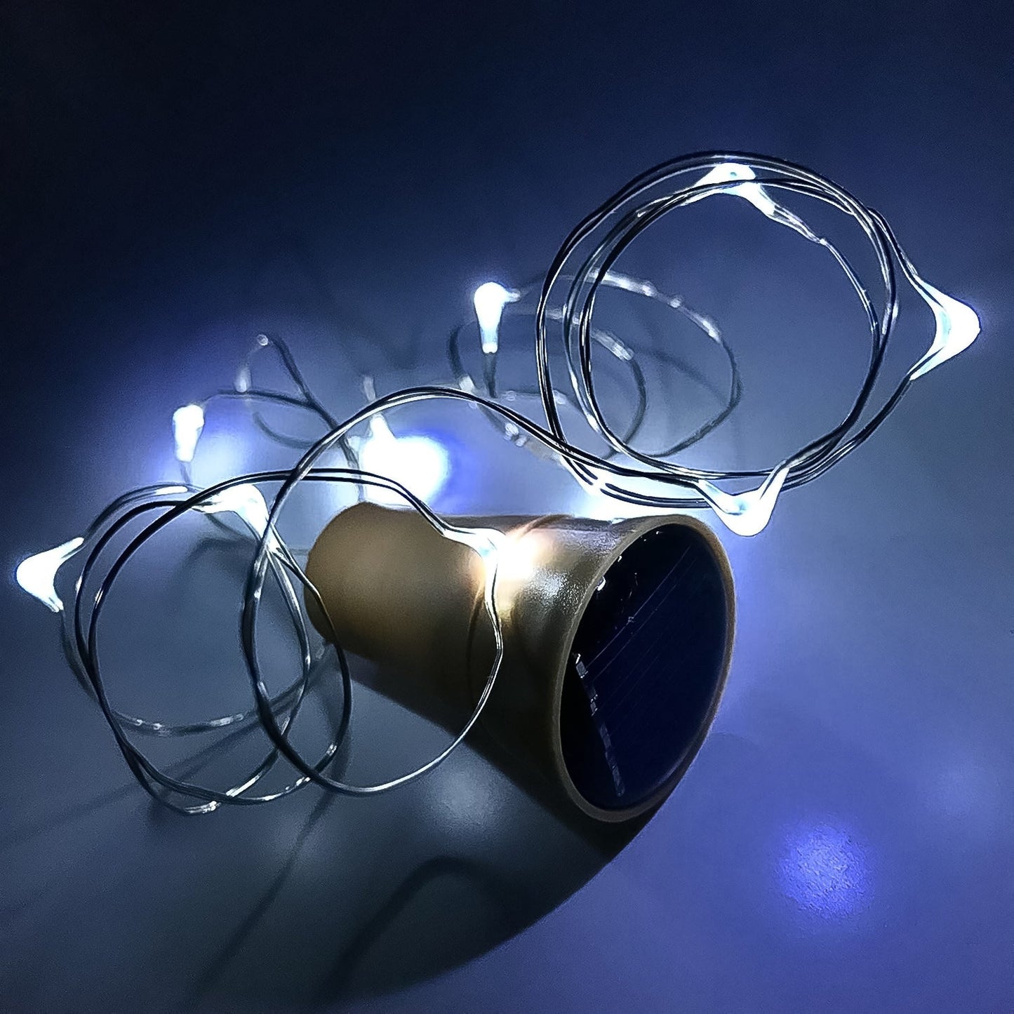 A set of multi-LED copper wire fairy lights emerging from a wine bottle cork.