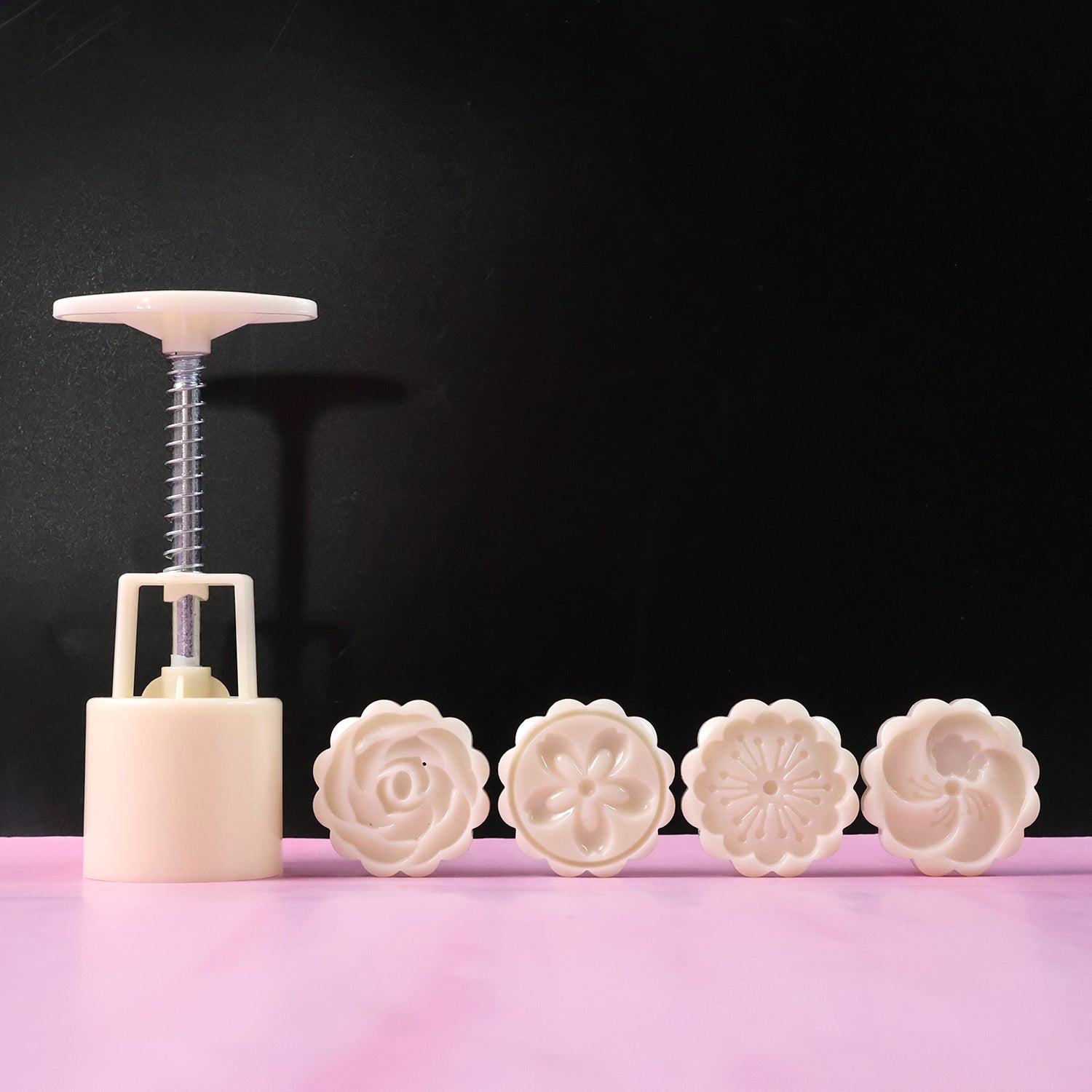 Angled view of 4-in-1 spring press cookie mold set for precise baking