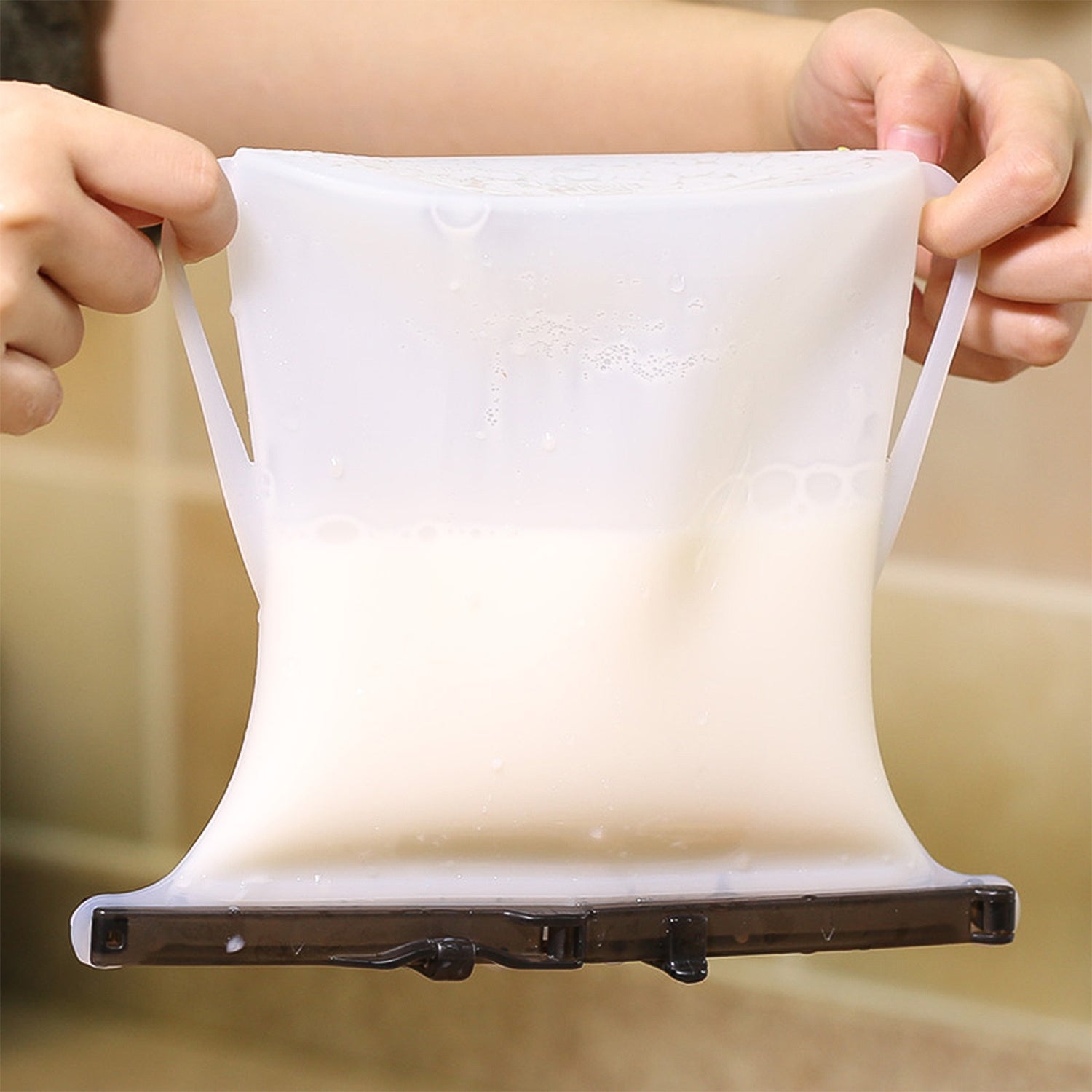 A hand holding a filled Reusable Silicone Food Storage Bag, ready for transport or storage.